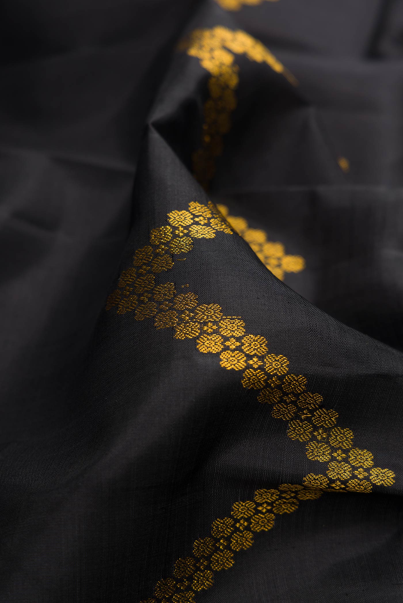 Close up of Black Dual Tone Kanjivaram Silk Saree with Stripes on the body and Plain Border.  displaying folds