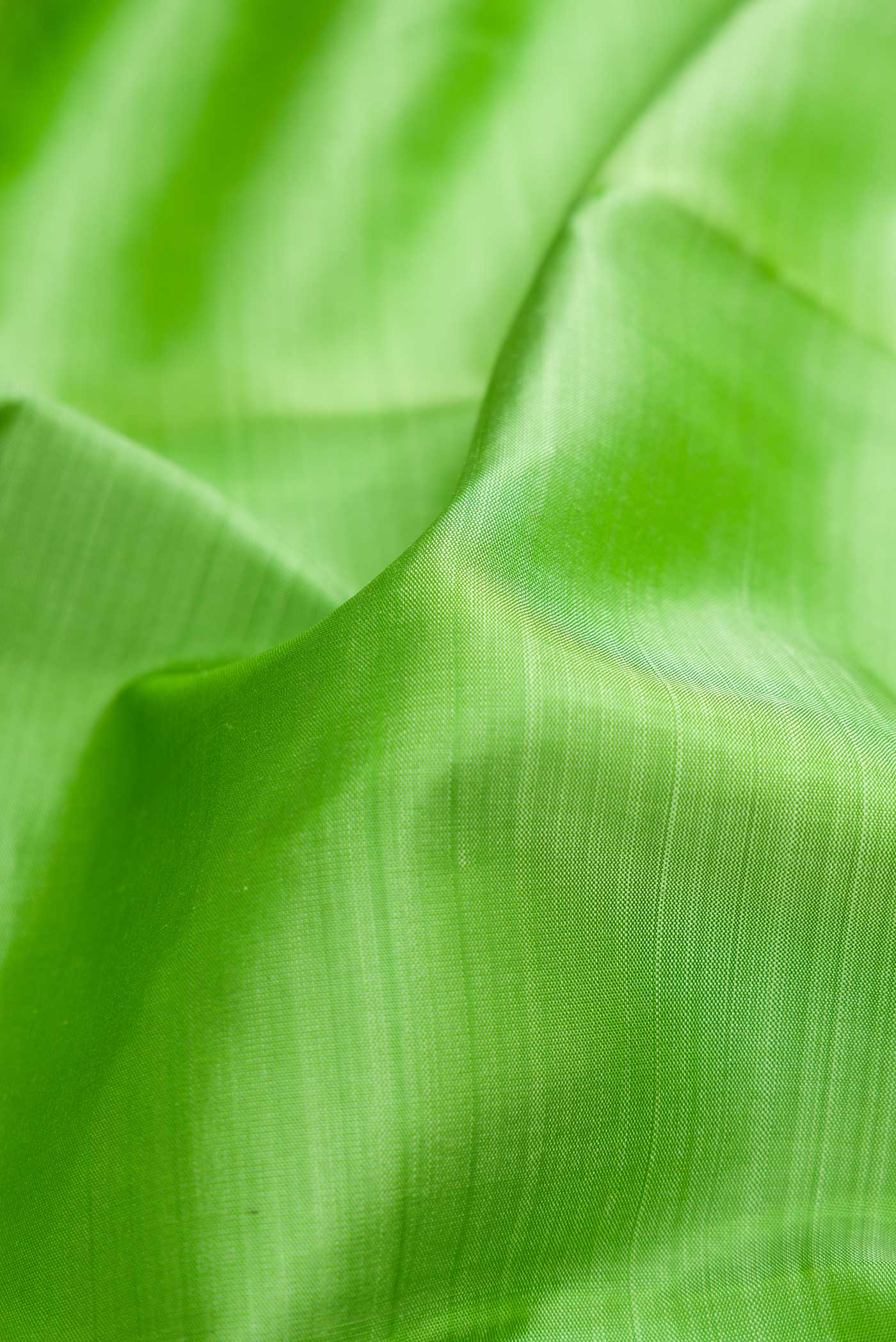 Close up of Pure Silk Pure Zari Parrot Green Dual Tone Kanjivaram Saree with Plain Body and Zari Border.  displaying folds