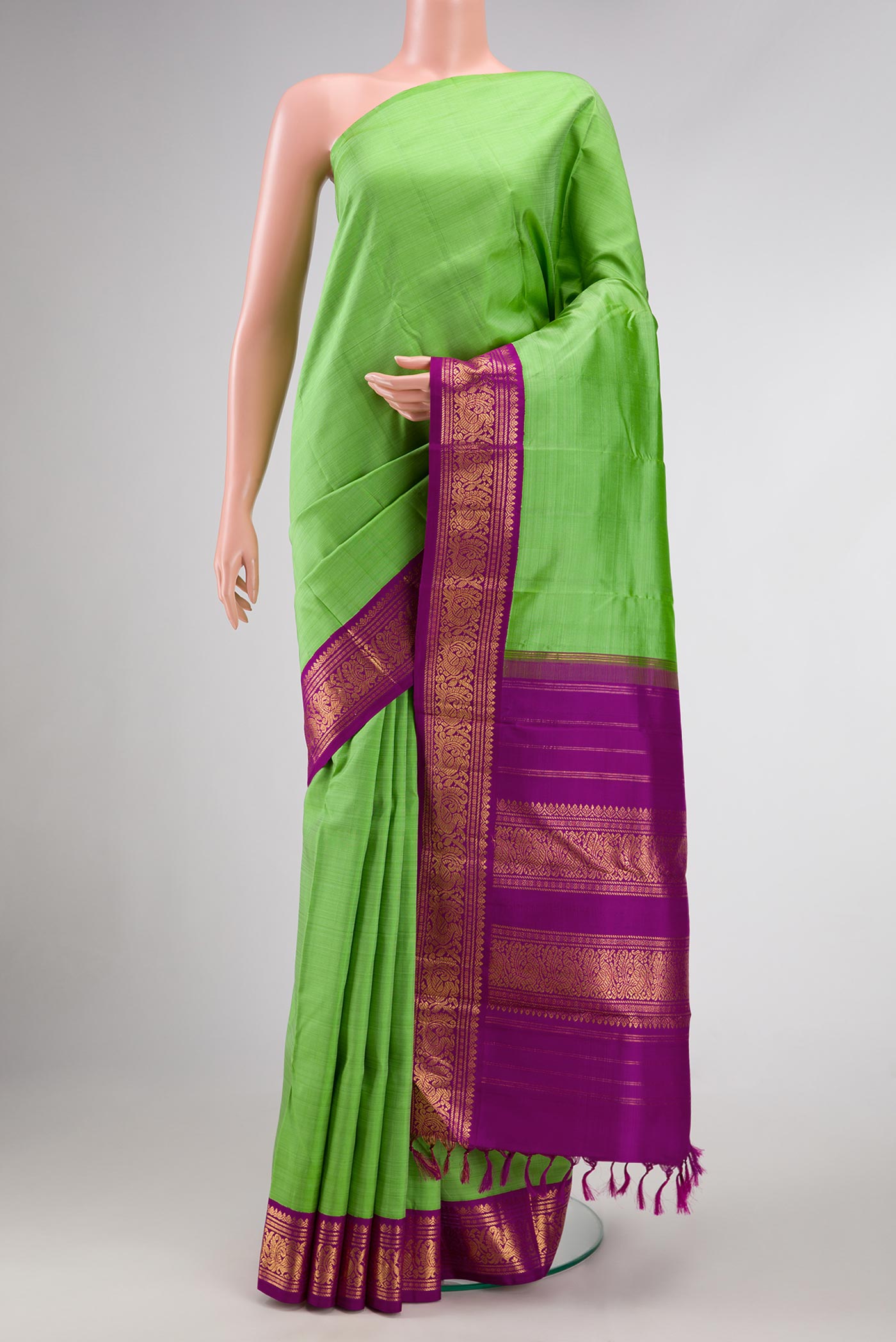 Pure Silk Pure Zari Parrot Green Dual Tone Kanjivaram Saree with Plain Body and Zari Border.  displayed on a mannequin