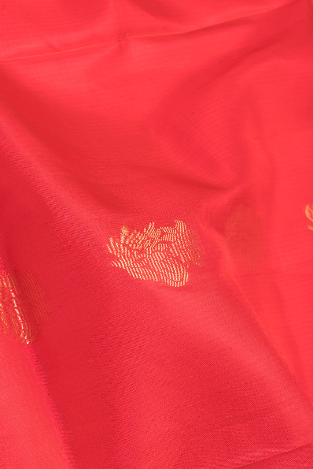 Close up of Orange Soft Silk Saree with Zari Butta on the body and Fancy Border.  displaying folds