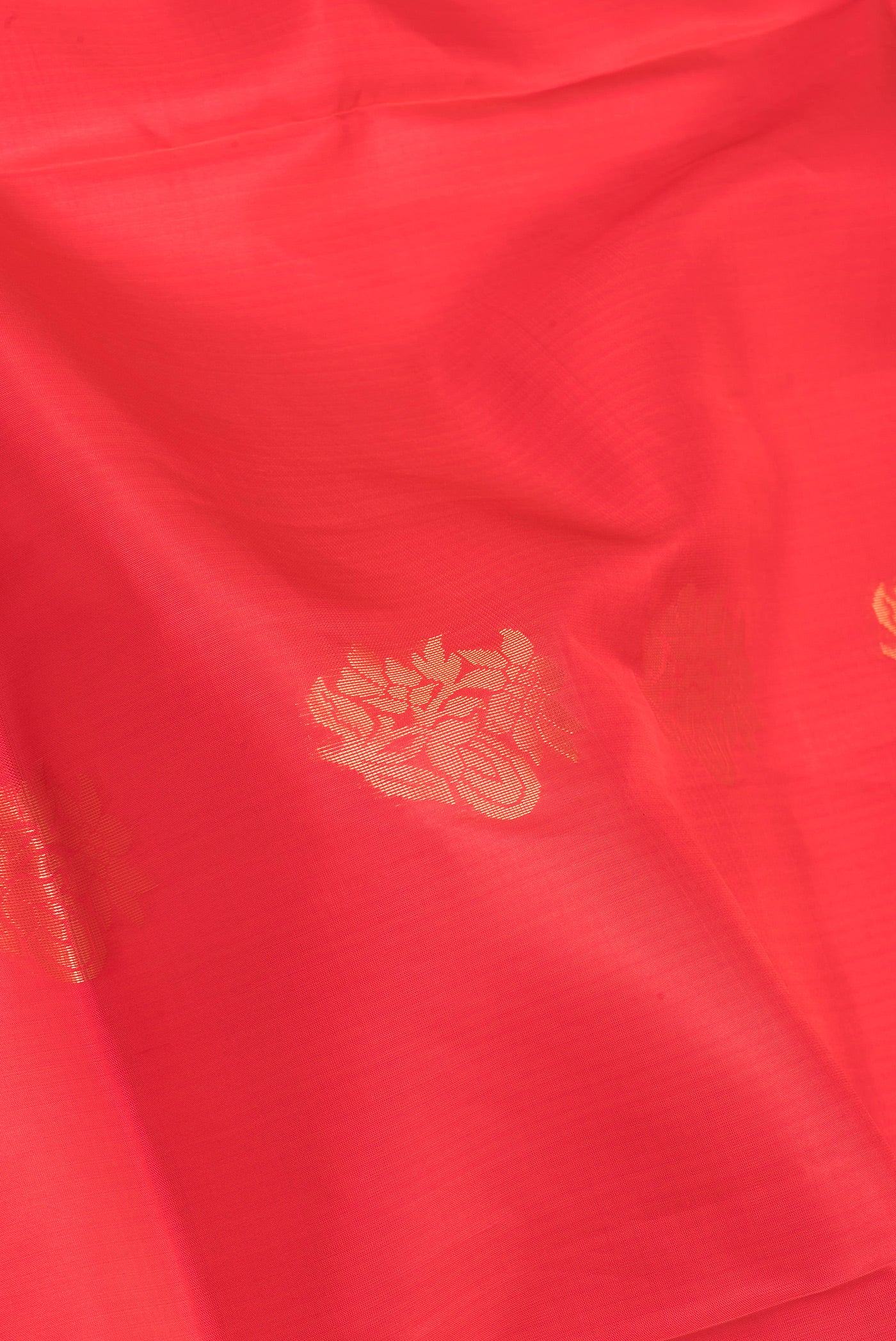Close up of Orange Soft Silk Saree with Zari Butta on the body and Fancy Border.  displaying folds
