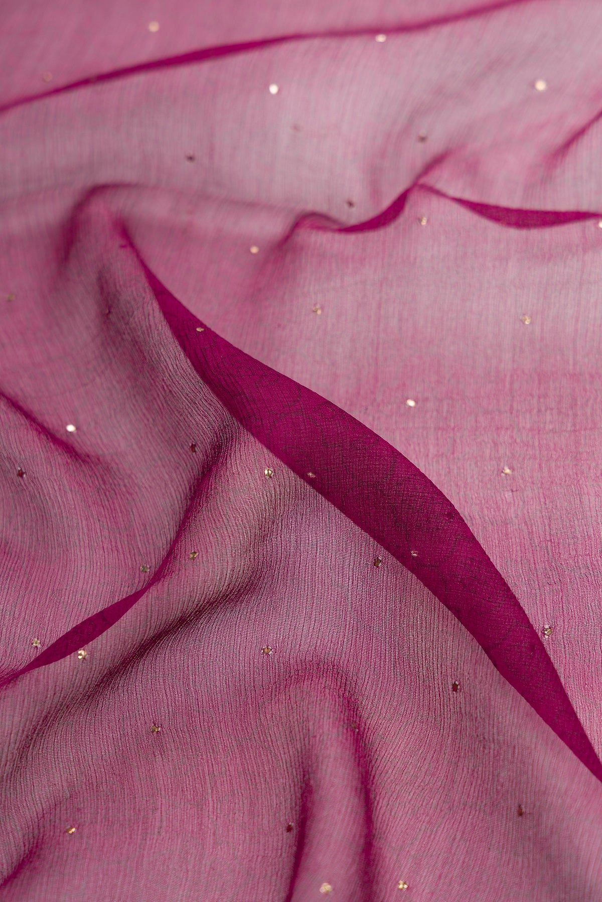 Close up of Maroon Dual Tone Chiffon Saree with Embroidery on the body and Embroidery Border.  displaying folds
