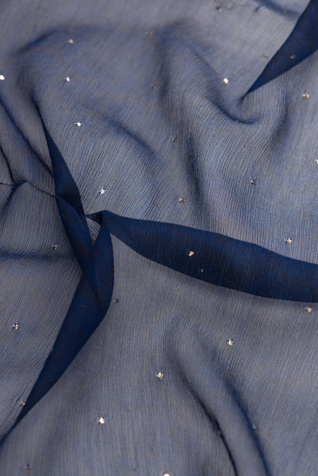 Close up of Navy Blue Dual Tone Chiffon Saree with Embroidery on the body and Embroidery Border.  displaying folds