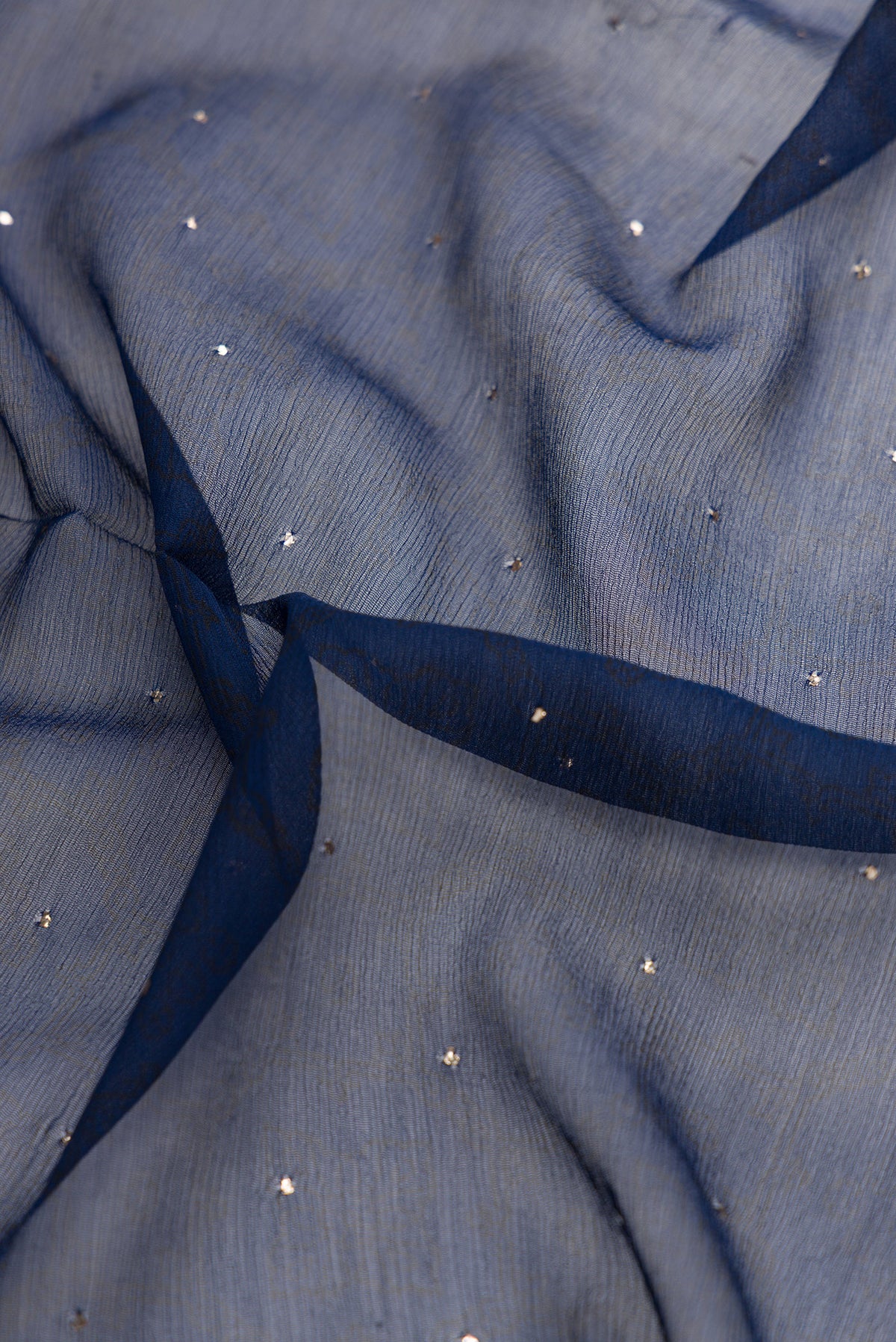 Close up of Navy Blue Dual Tone Chiffon Saree with Embroidery on the body and Embroidery Border.  displaying folds
