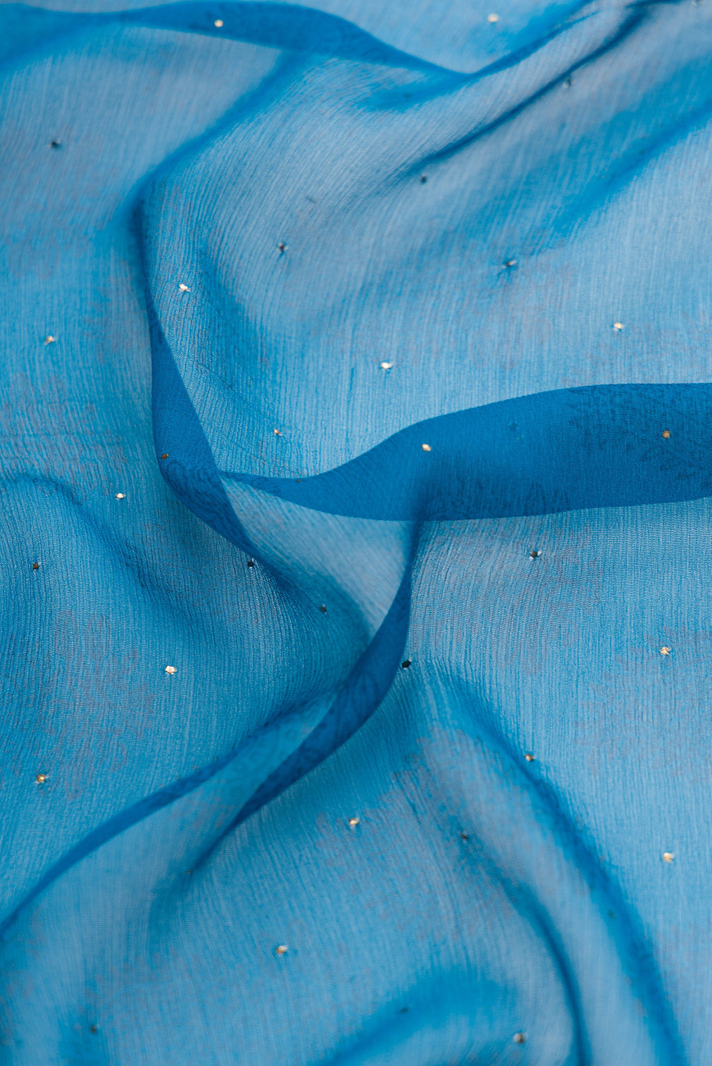 Close up of Sky Blue Dual Tone Chiffon Saree with Embroidery on the body and Embroidery Border.  displaying folds