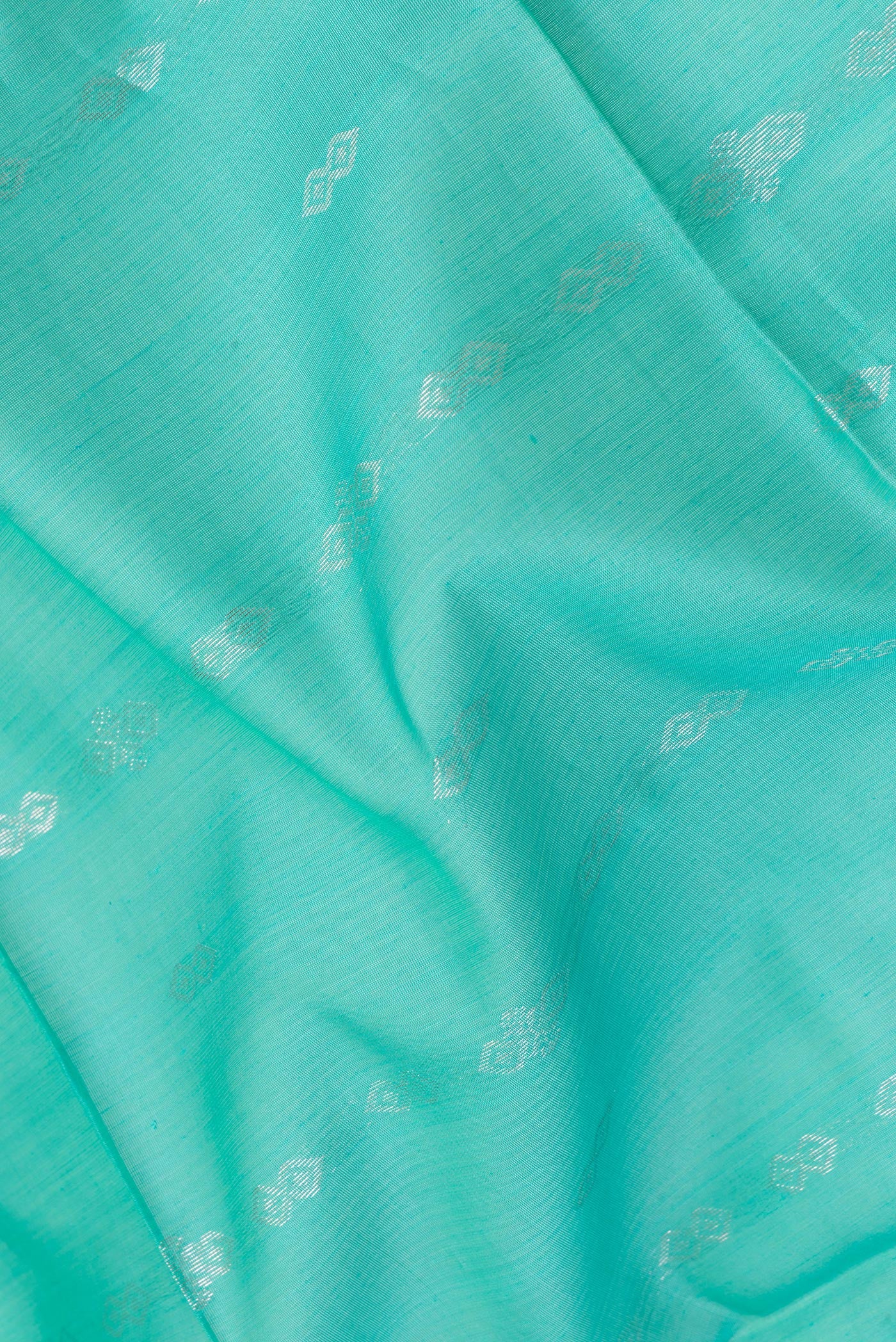 Close up of Sea Green Silk Cotton Saree with Zari Butta on the body and Zari Border.  displaying folds