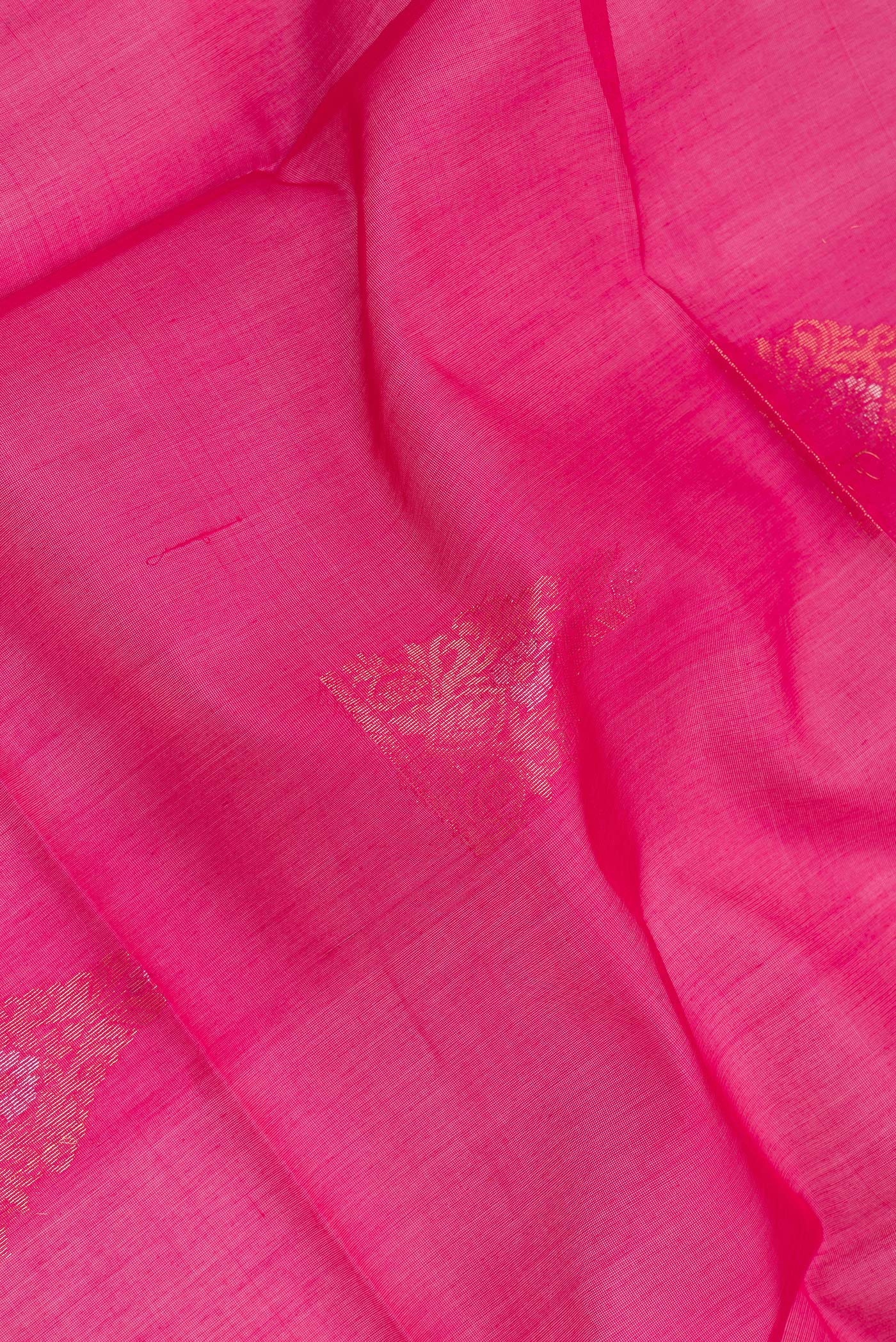 Close up of Dark Pink Silk Cotton Saree with Zari Butta on the body and Zari Border.  displaying folds