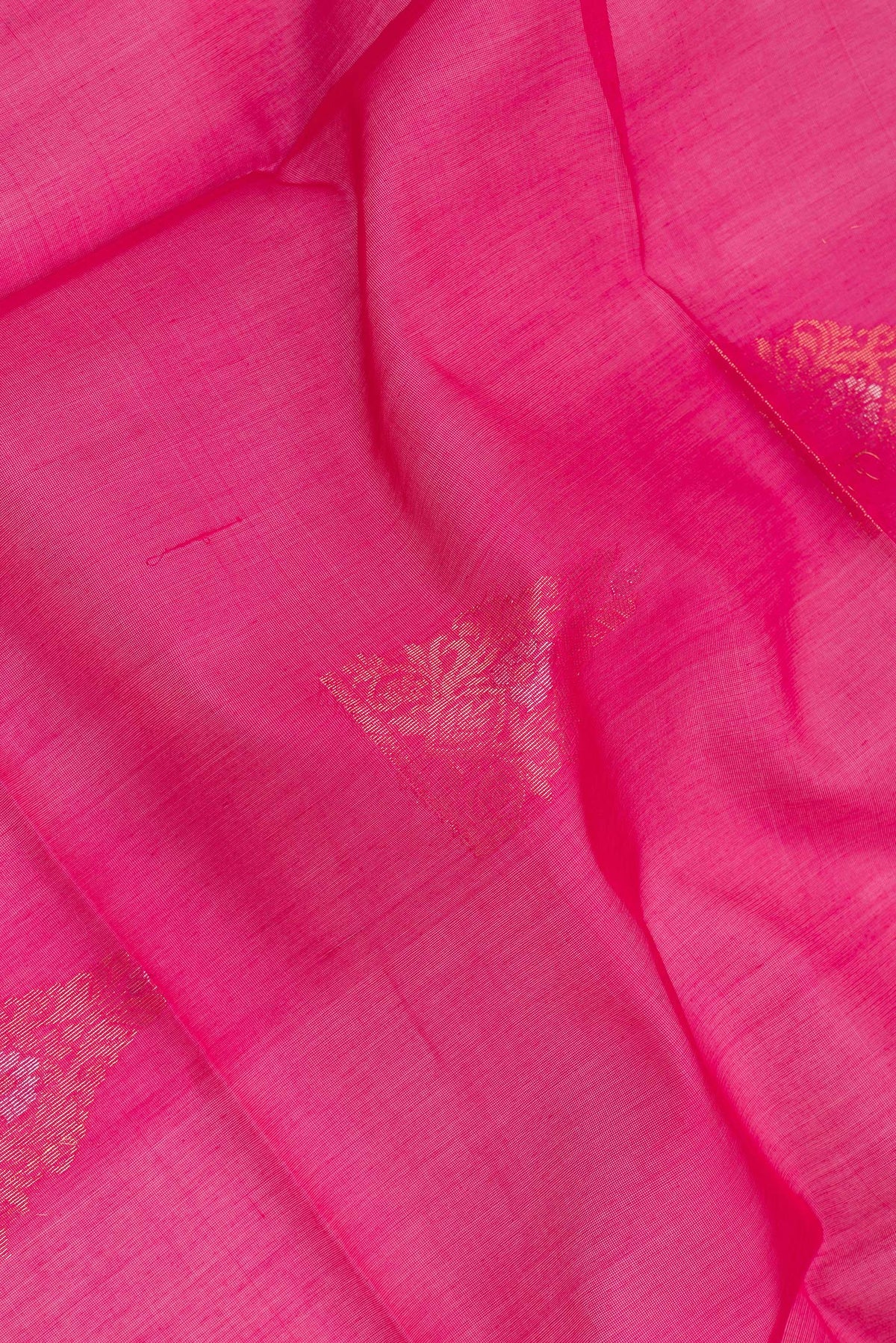 Close up of Dark Pink Silk Cotton Saree with Zari Butta on the body and Zari Border.  displaying folds