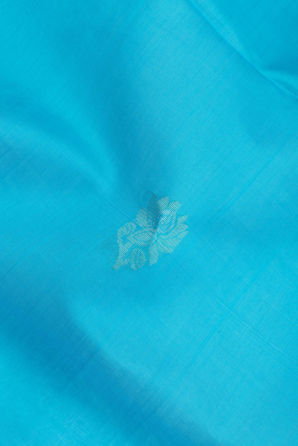 Close up of Sky Blue Silk Cotton Saree with Zari Butta on the body and Zari Border.  displaying folds