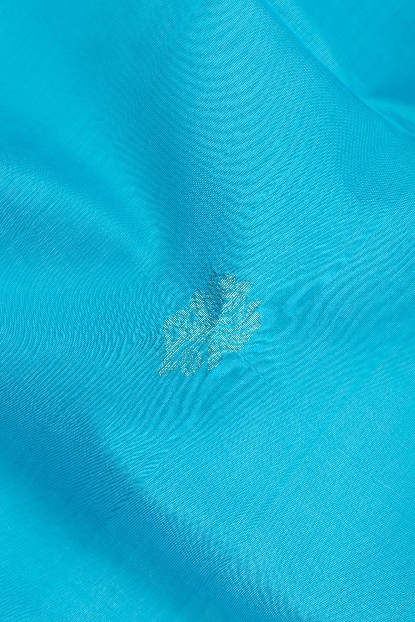 Close up of Sky Blue Silk Cotton Saree with Zari Butta on the body and Zari Border.  displaying folds