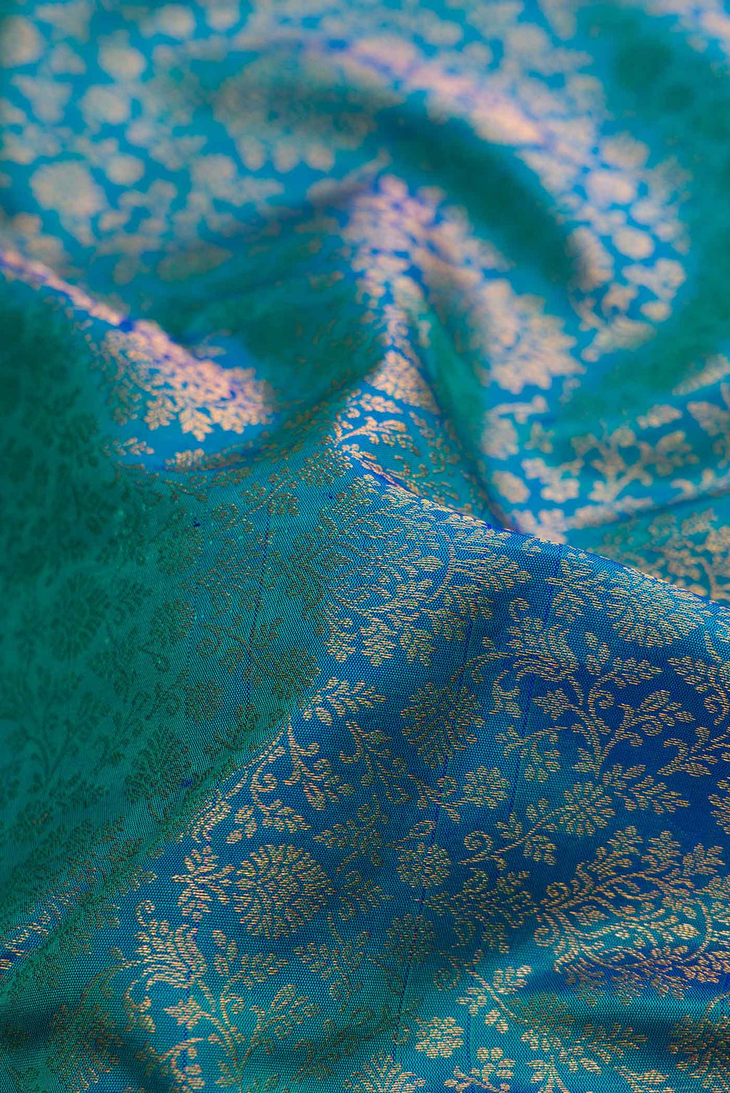 Close up of Peacock Blue Dual Tone Kanjivaram Silk Saree with Zari Brocade on the body and Zari Border.  displaying folds