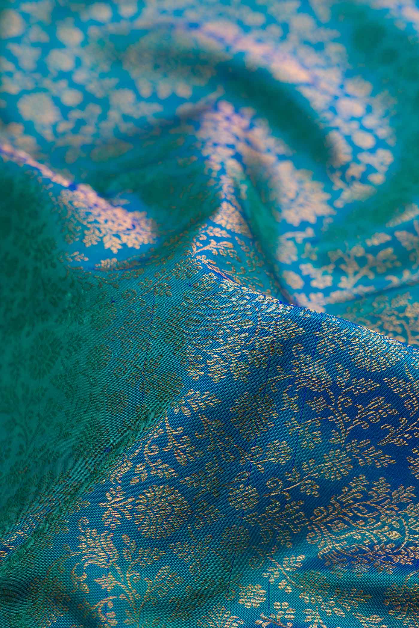 Close up of Peacock Blue Dual Tone Kanjivaram Silk Saree with Zari Brocade on the body and Zari Border.  displaying folds