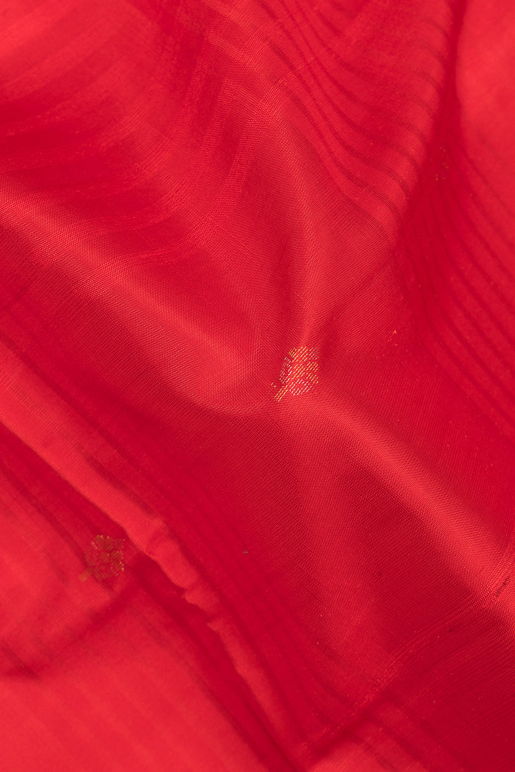 Close up of Pure Silk Red Soft Saree with Zari Butta on the body and Fancy Border.  displaying folds