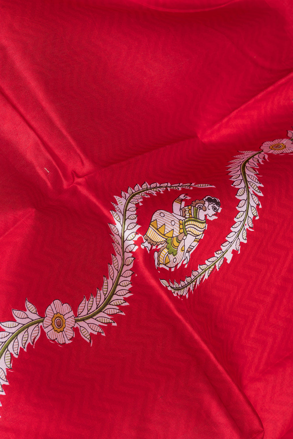 Close up of Red Printed Silk Saree with Printed design on the body and Fancy Border.  displaying folds