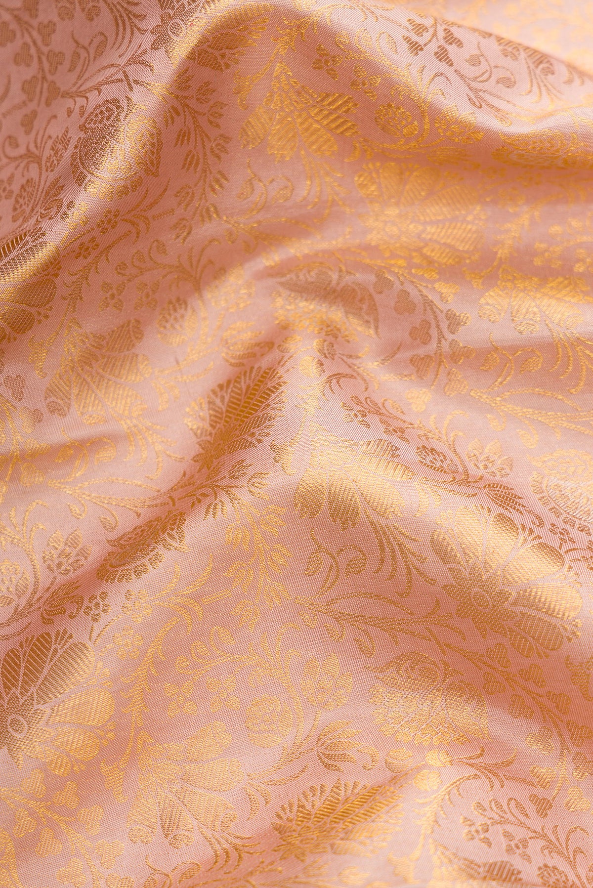 Close up of Rose Gold Dual Tone Kanjivaram Silk Saree with Zari Brocade on the body and Zari Border.  displaying folds