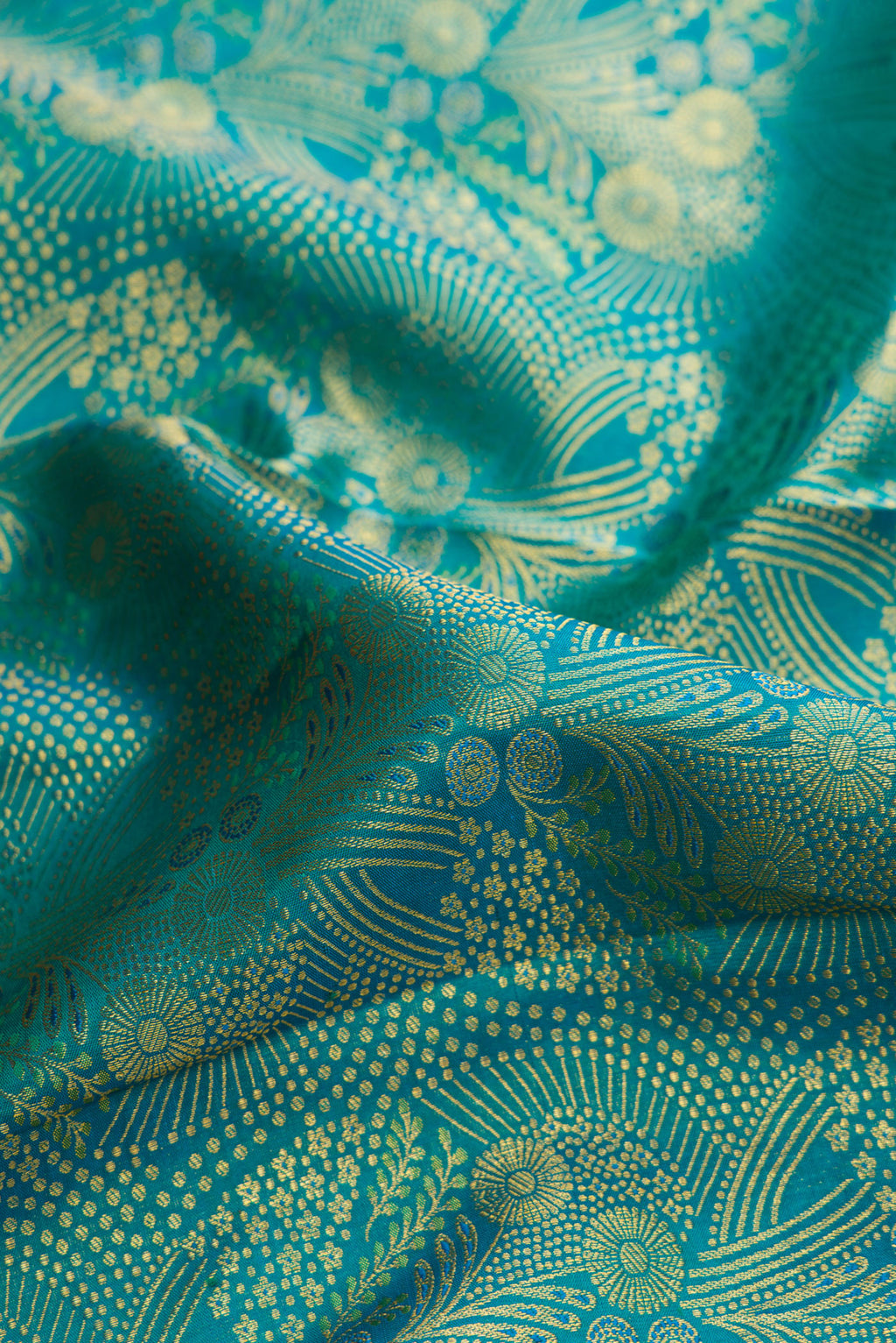 Close up of Green Dual Tone Kanjivaram Silk Saree with Zari Brocade on the body and Zari Border.  displaying folds