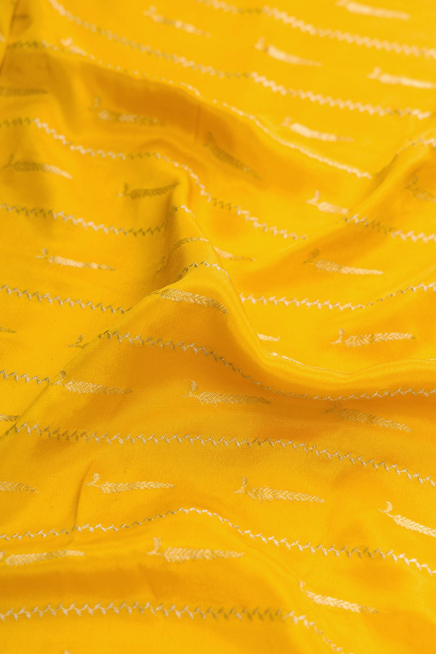 Close up of Mustard Dual Tone Mysore Georgette Saree with Stripes on the body and Zari And Thread Border.  displaying folds