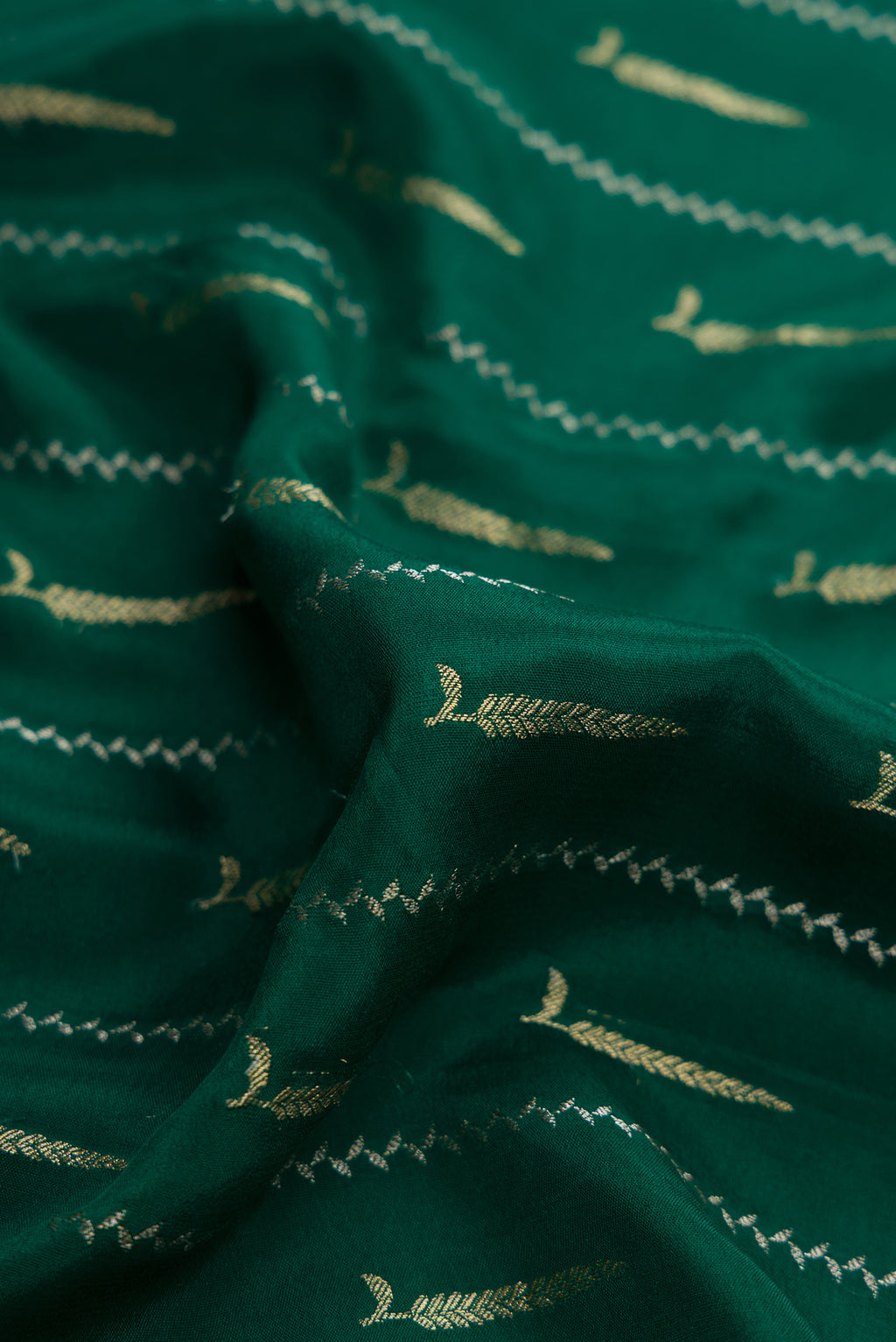 Close up of Bottle Green Dual Tone Mysore Silk Saree with Zari Butta on the body and Zari And Thread Border.  displaying folds