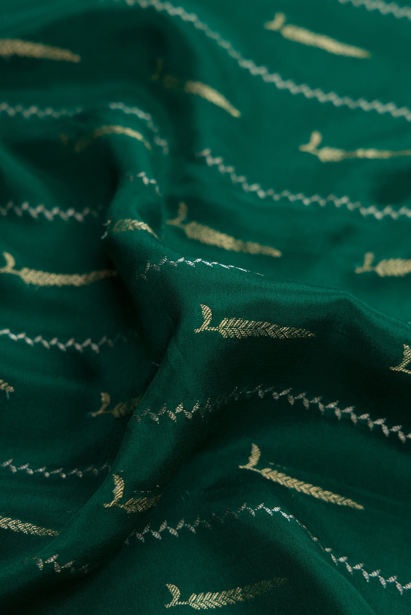 Close up of Bottle Green Dual Tone Mysore Silk Saree with Zari Butta on the body and Zari And Thread Border.  displaying folds