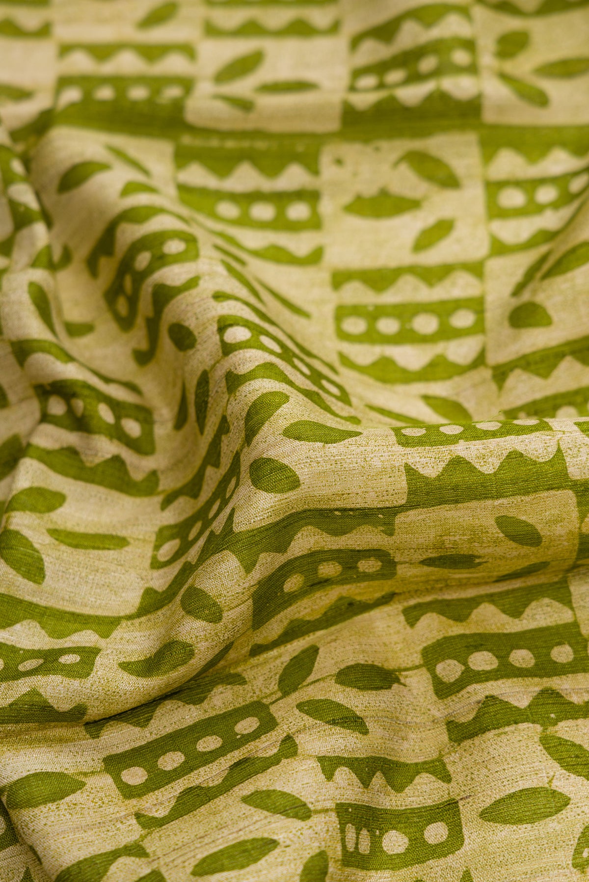 Close up of Mehandi Green Dual Tone Tussar Silk Saree with Printed design on the body and Fancy Border.  displaying folds