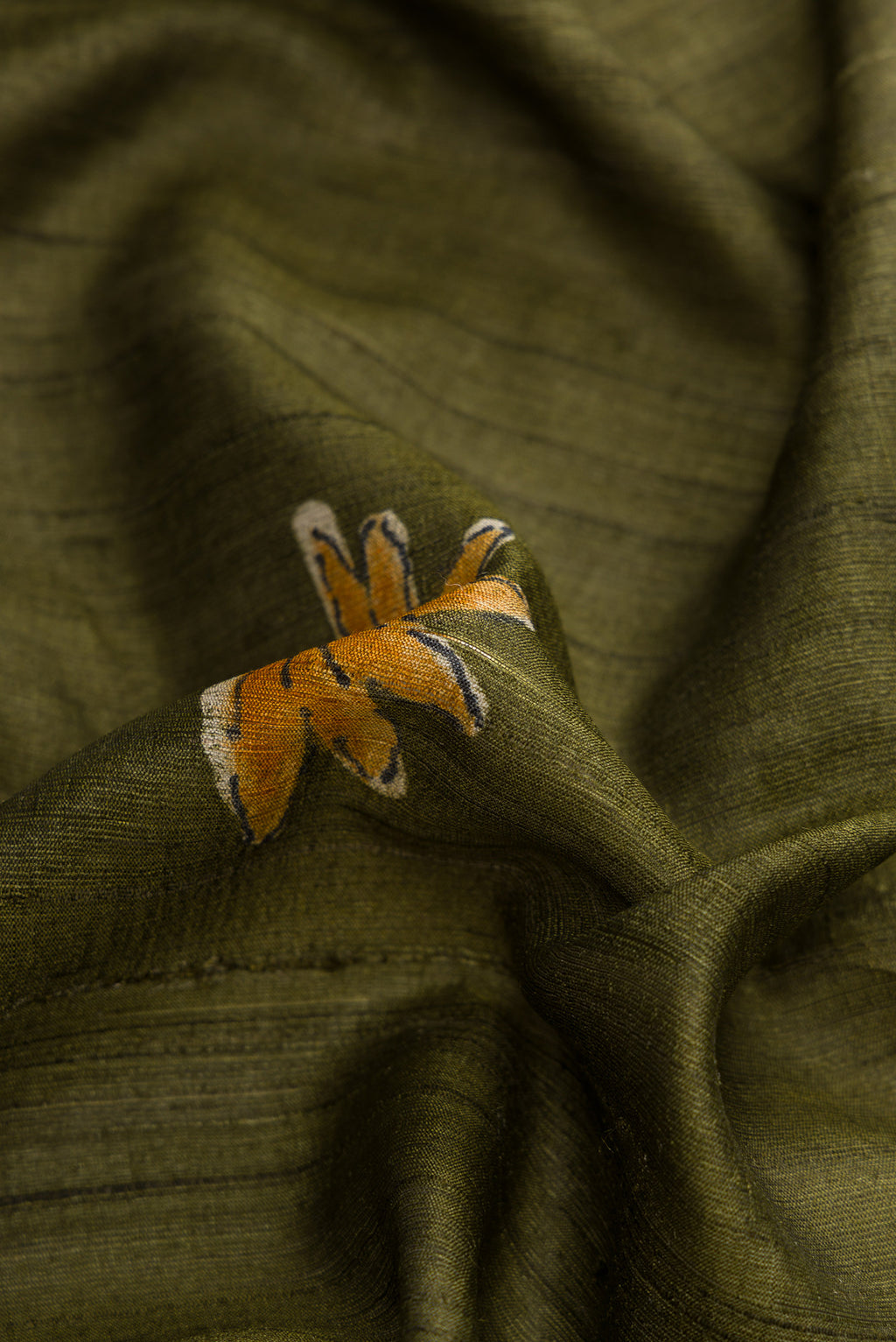 Close up of Green Dual Tone Tussar Silk Saree with Printed design on the body and Plain Border.  displaying folds