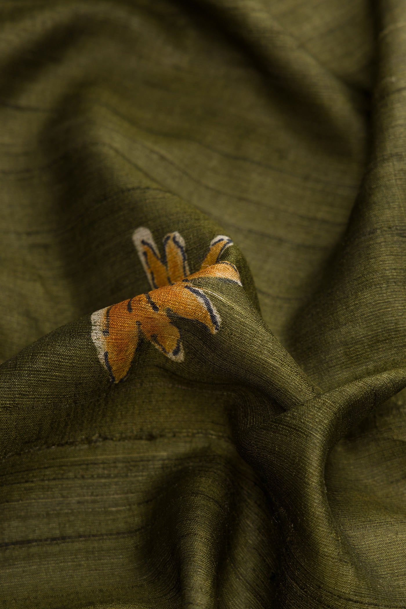 Close up of Green Dual Tone Tussar Silk Saree with Printed design on the body and Plain Border.  displaying folds
