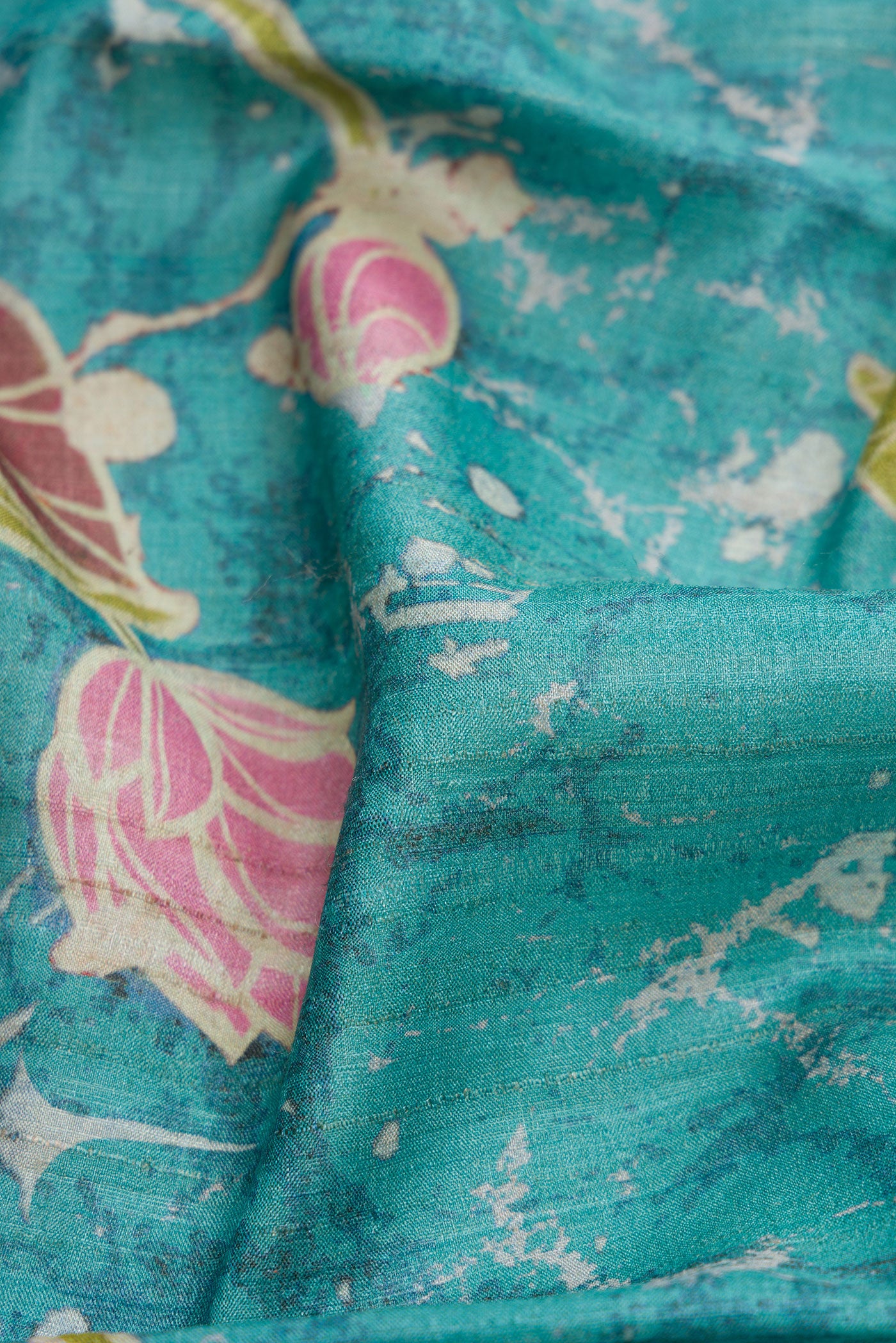 Close up of Maya Blue Dual Tone Tussar Silk Saree with Printed design on the body and Embroidery Border.  displaying folds