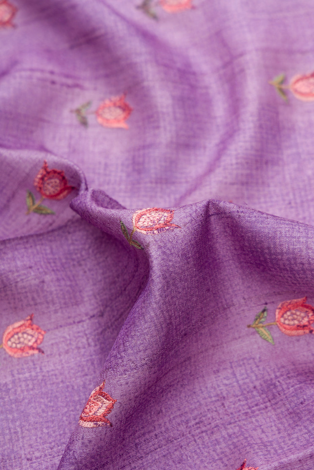 Close up of Lavender Dual Tone Tussar Silk Saree with Printed design on the body and Embroidery Border.  displaying folds