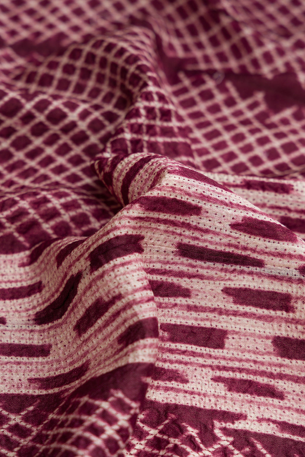 Close up of Maroon Dual Tone Tussar Silk Saree with Printed design on the body and Printed Border.  displaying folds