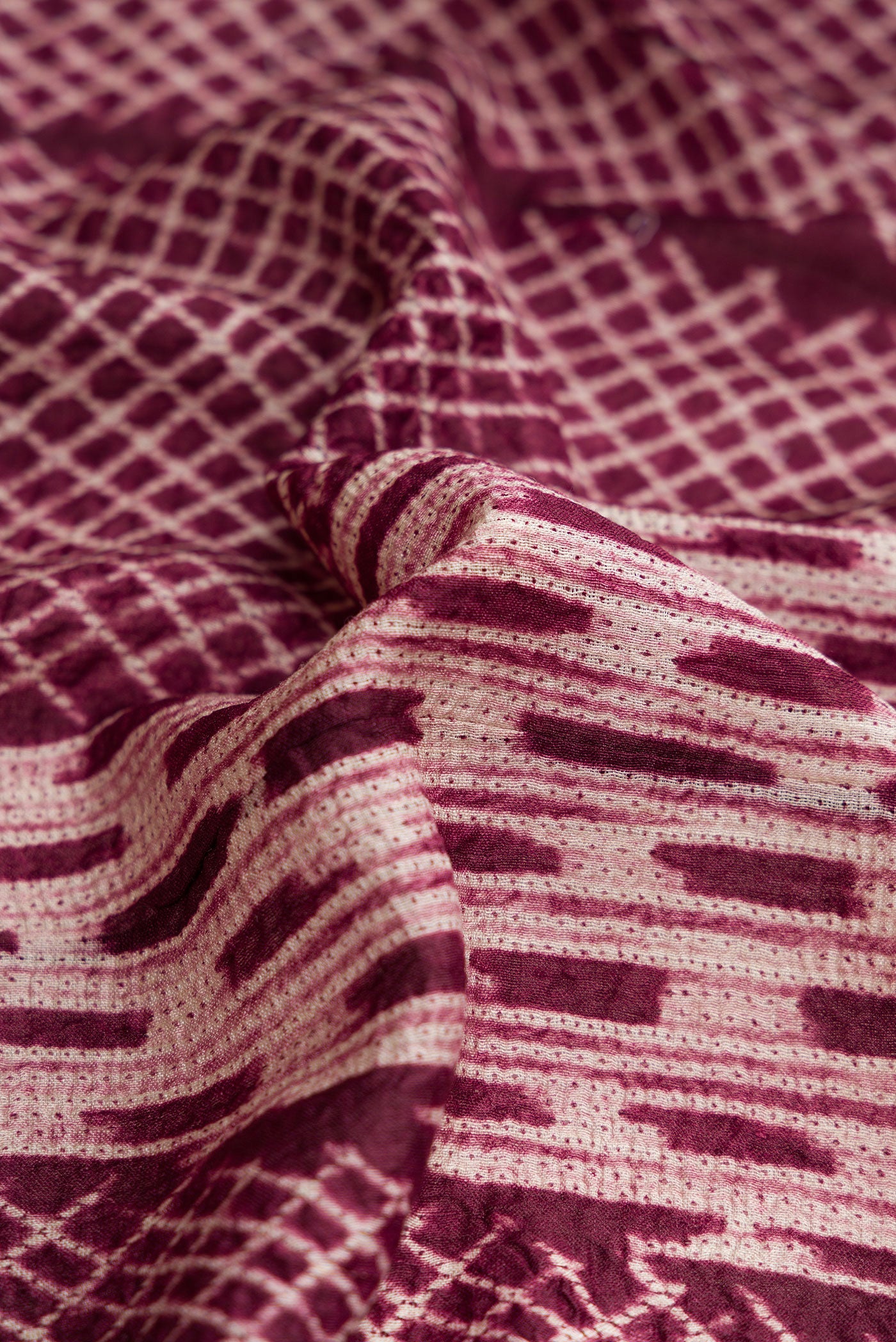 Close up of Maroon Dual Tone Tussar Silk Saree with Printed design on the body and Printed Border.  displaying folds