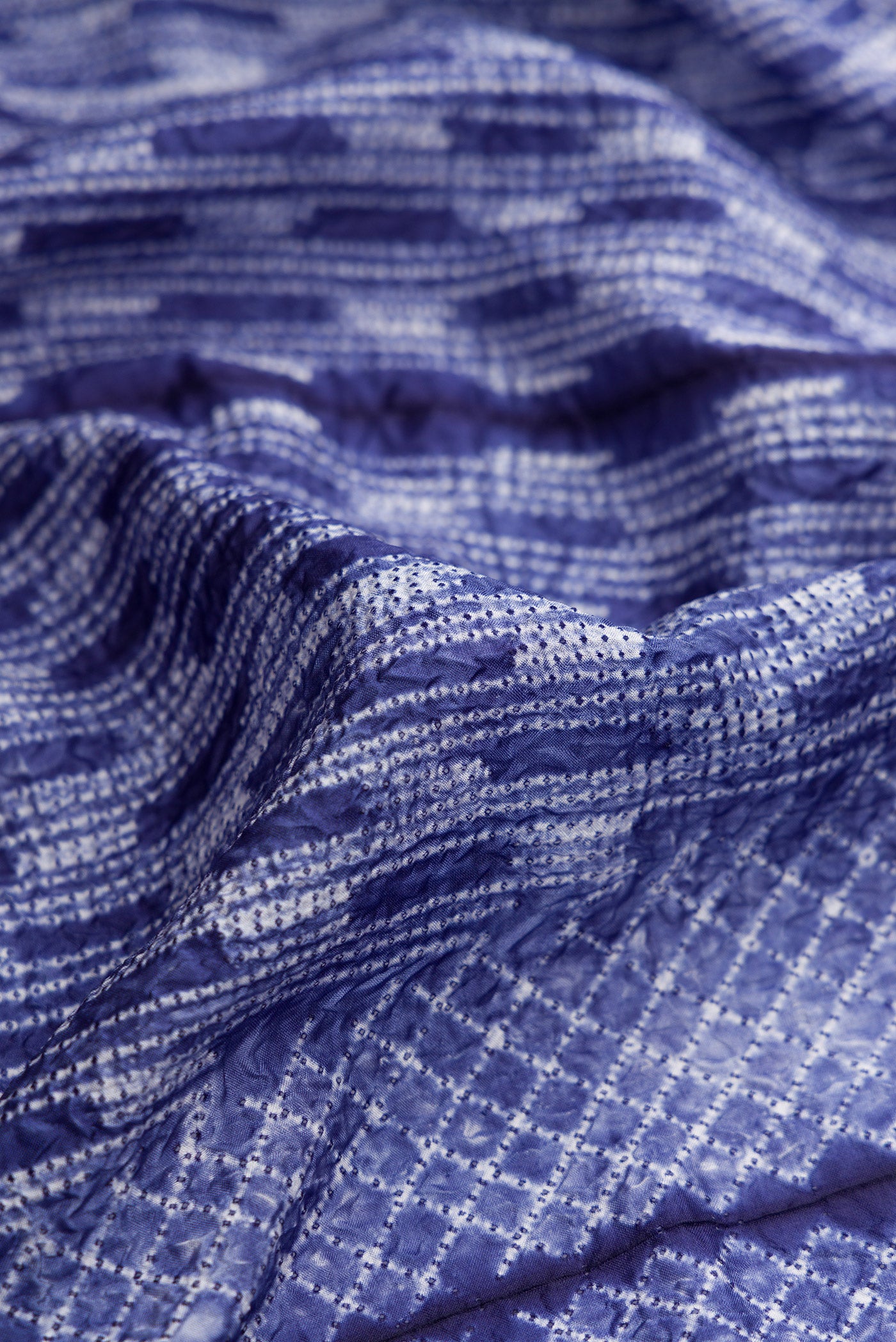 Close up of Violet Dual Tone Tussar Silk Saree with Printed design on the body and Without Border.  displaying folds