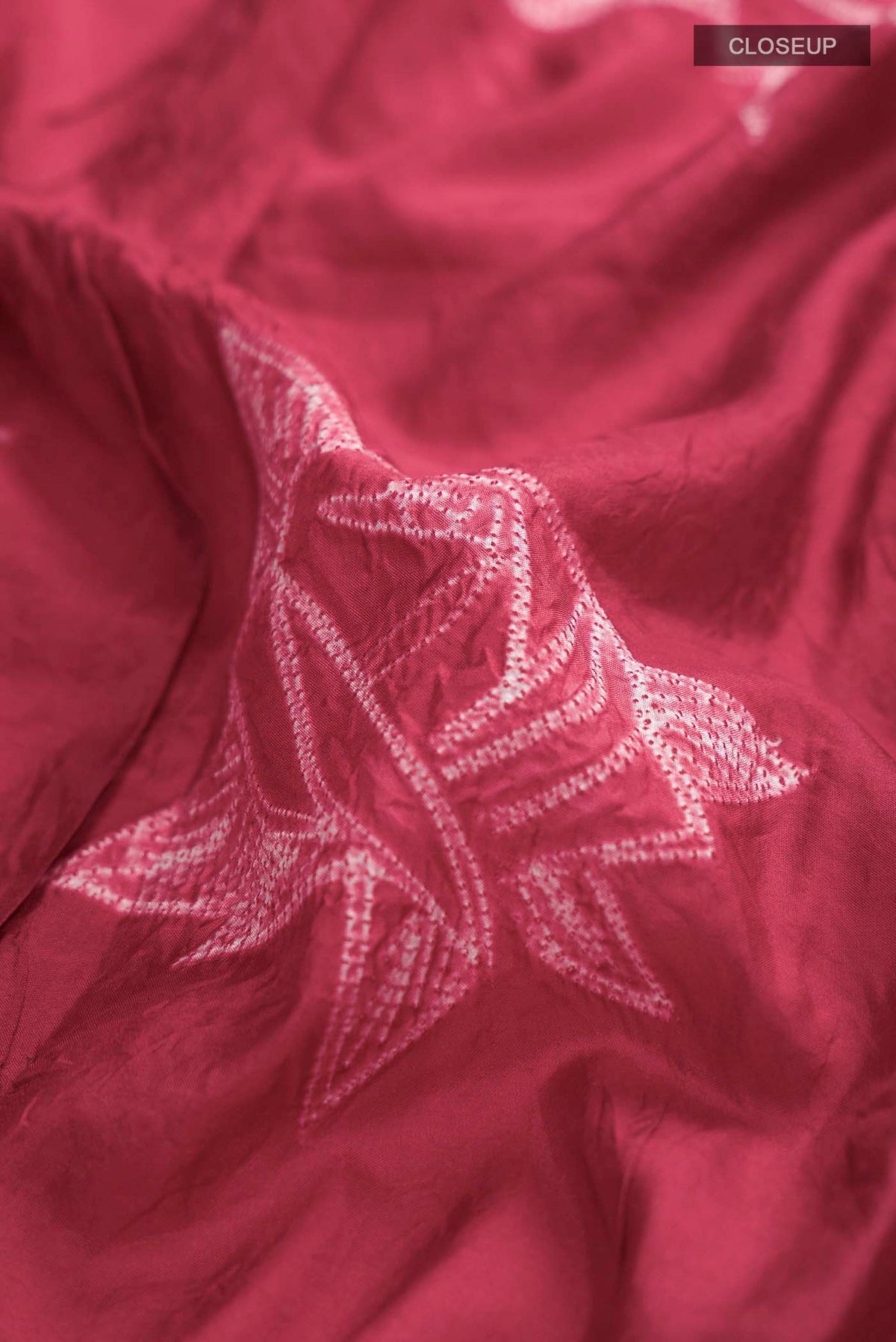 Close up of Red Tussar Silk Saree Printed design on the body and Without Border displaying folds