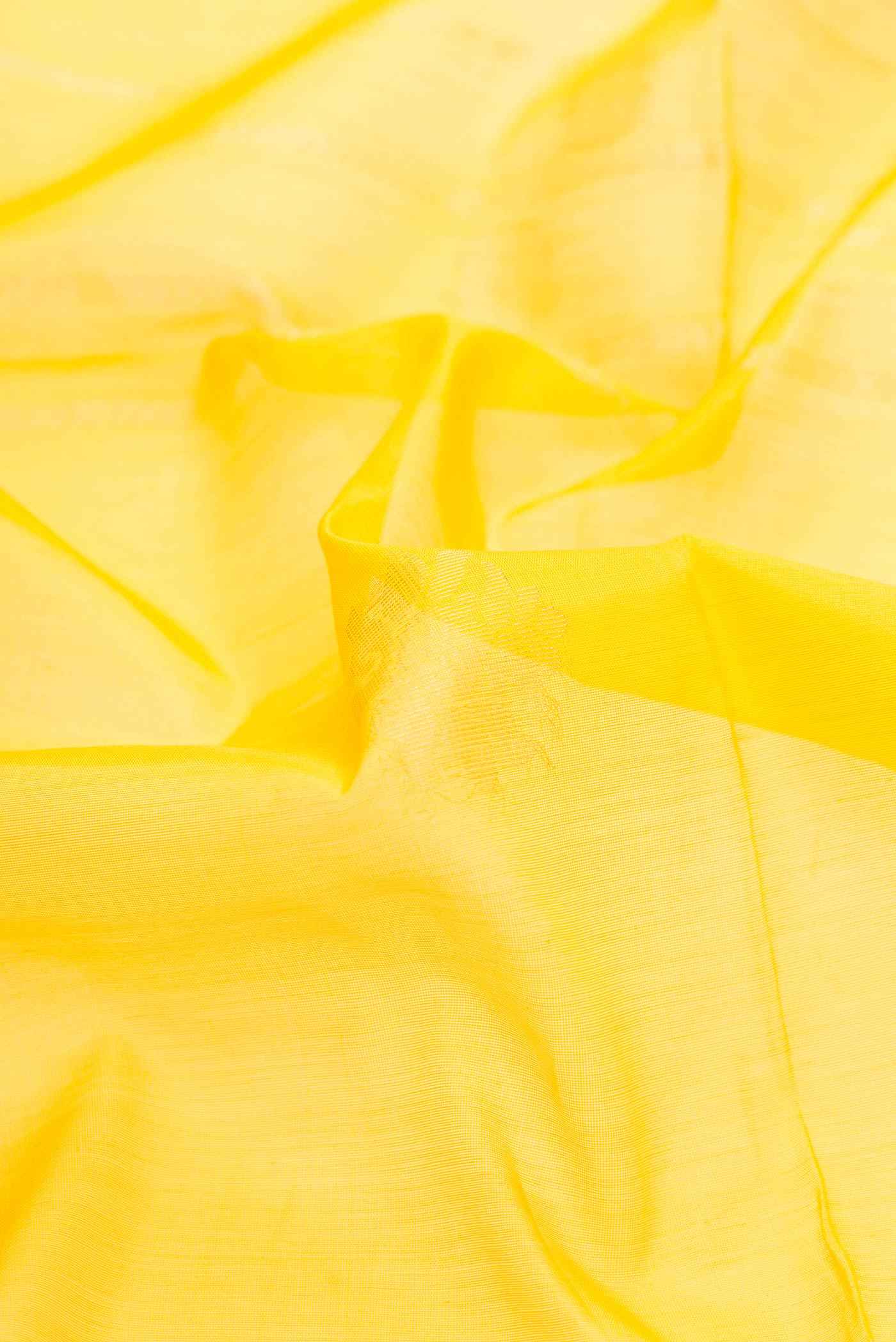 Close up of Yellow Dual Tone Silk Cotton Saree with Zari Butta on the body and Zari Border displaying folds