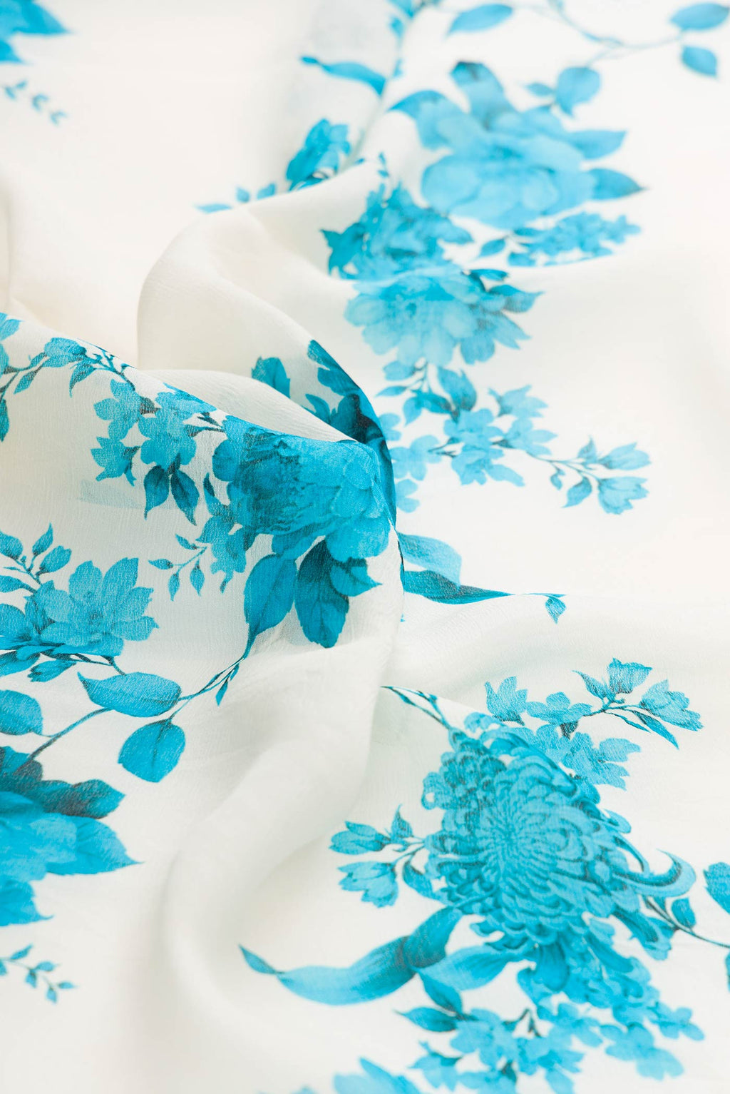 Close up of White Mysore Georgette Saree with Floral Print on the body and Zari Border displaying folds