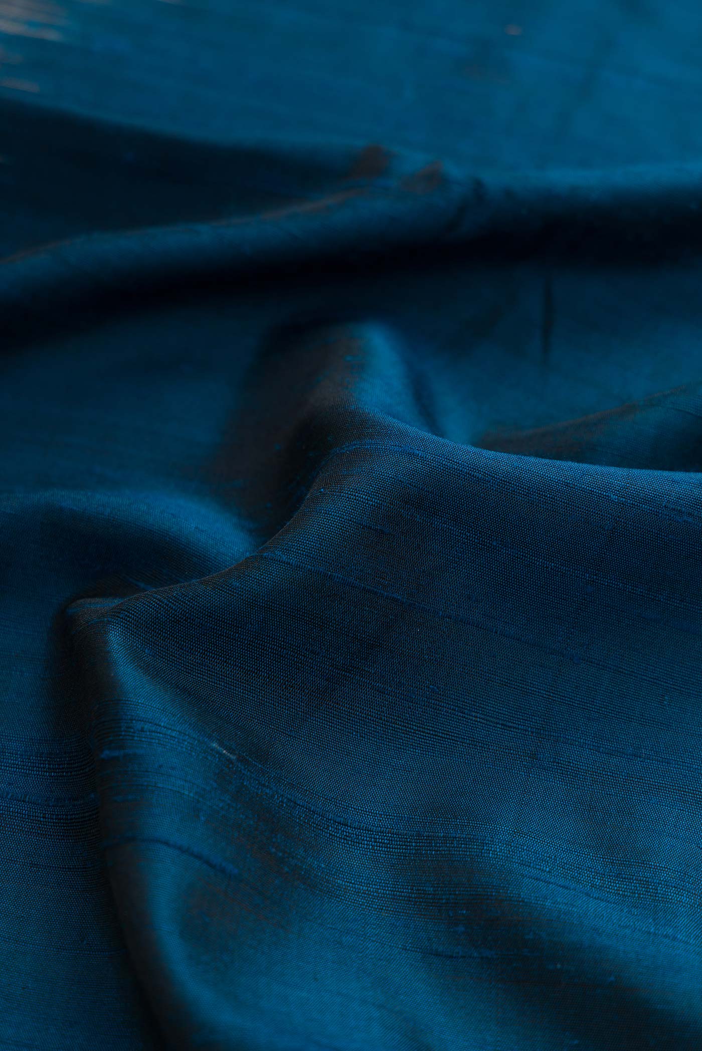 Close up of Navy Blue Dual Tone Kanchipuram Silk Saree with Plain Body and Printed Border displaying folds