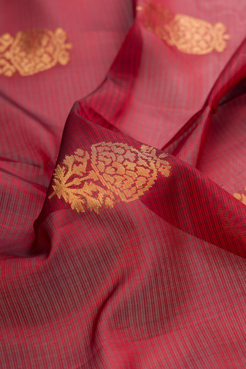 Close up of Pure Silk Maroon Soft Saree with Zari Butta on the body and Zari Border.  displaying folds