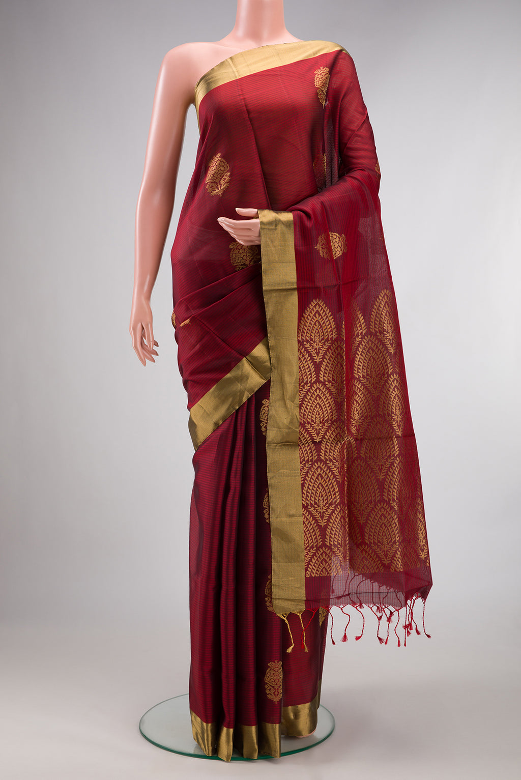 Pure Silk Maroon Soft Saree with Zari Butta on the body and Zari Border.  displayed on a mannequin