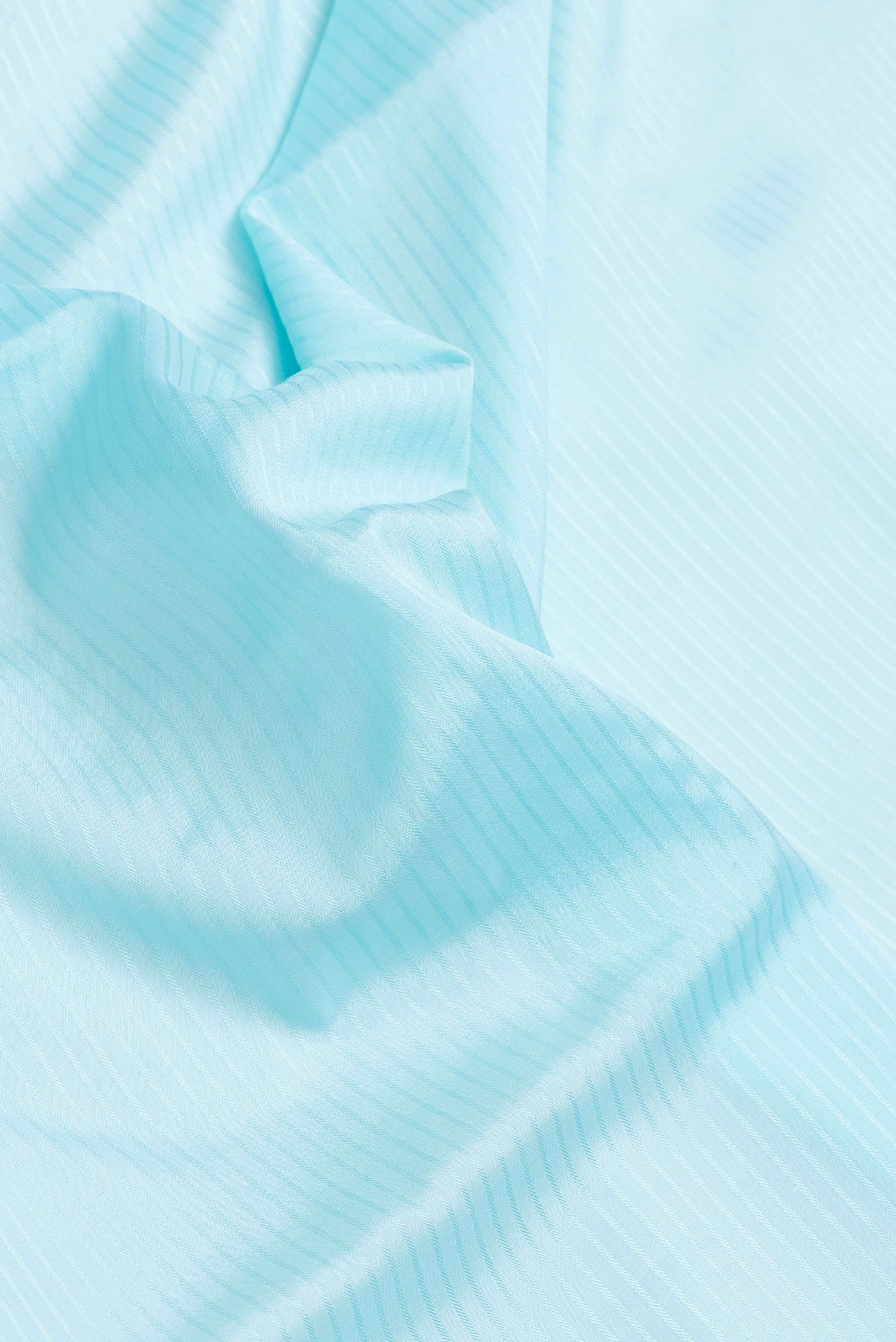 Close up of Sky Blue Dual Tone Mysore Silk Saree with Stripes on the body and Embroidery Border.  displaying folds