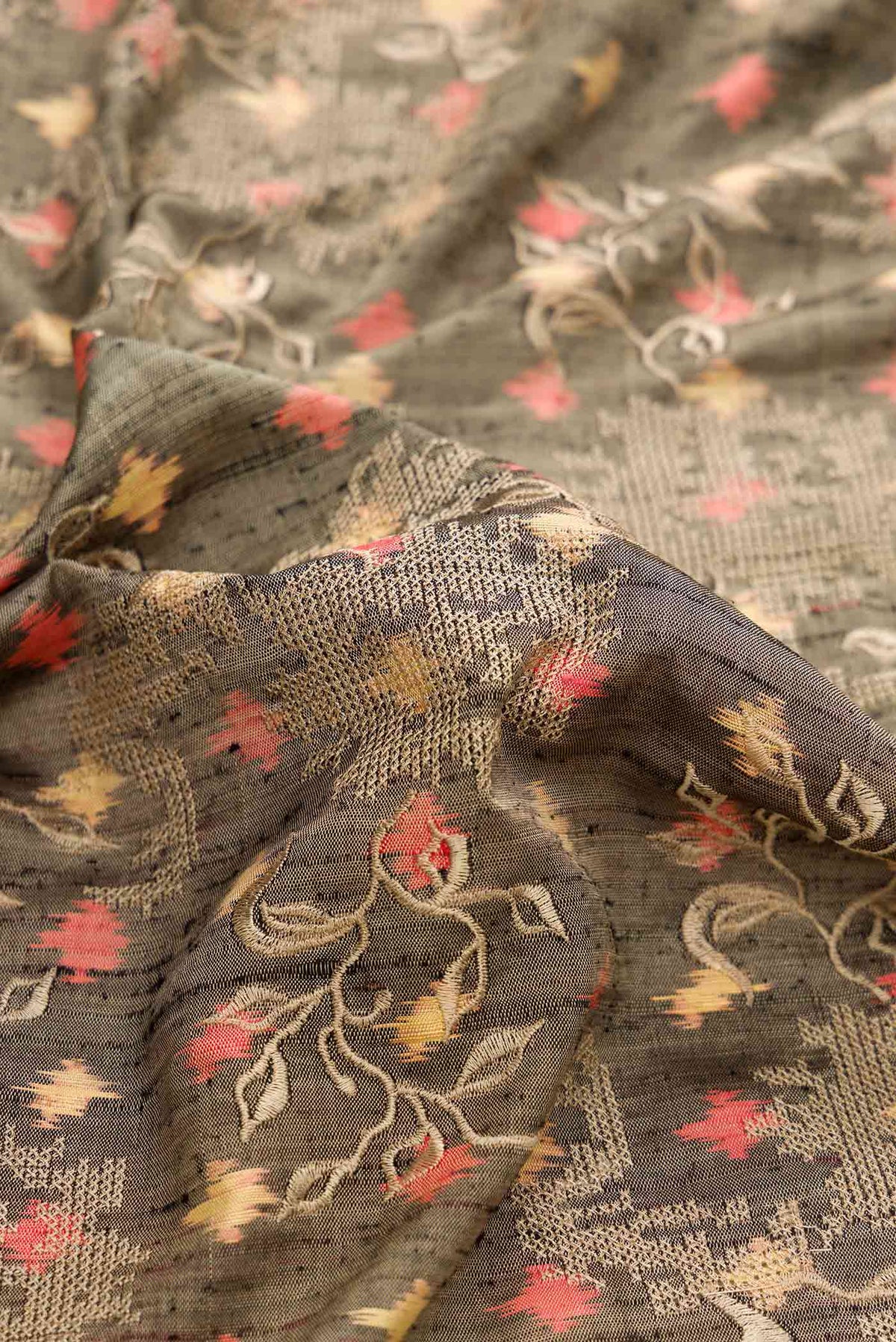 Close up of Grey Dual Tone Rajkot Patola Silk Saree with Ikat Print on the body and Zari Border displaying folds