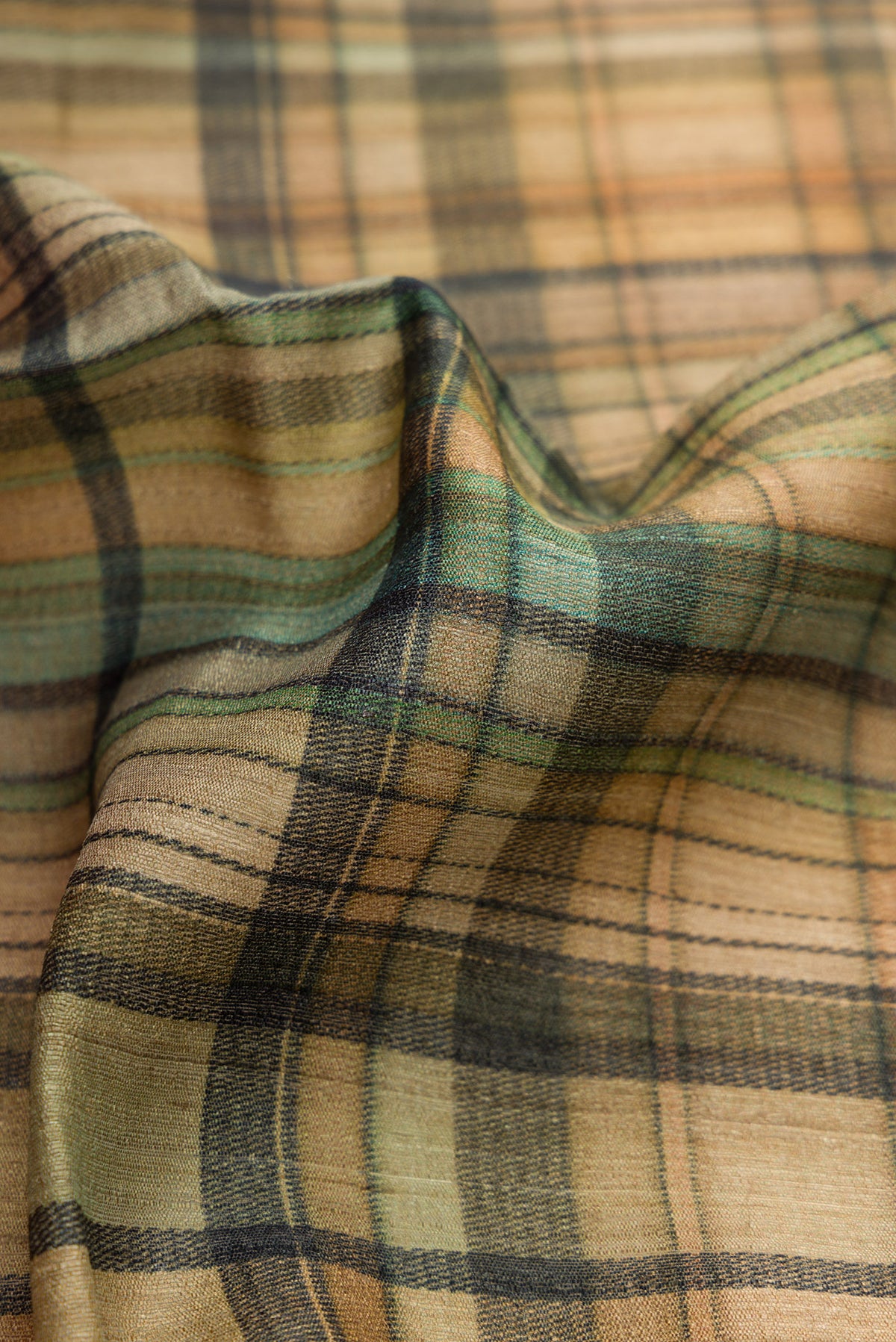 Close up of Mehandi Green Dual Tone Tussar Saree with Printed design on the body and Zari Border.  displaying folds