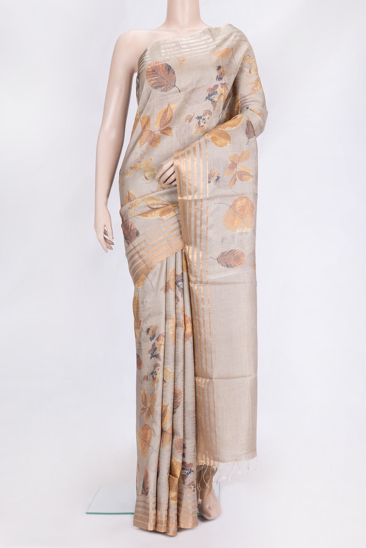 Beige Dual Tone Tussar Silk Saree with Printed design on the body and Zari Border.  displayed on a mannequin