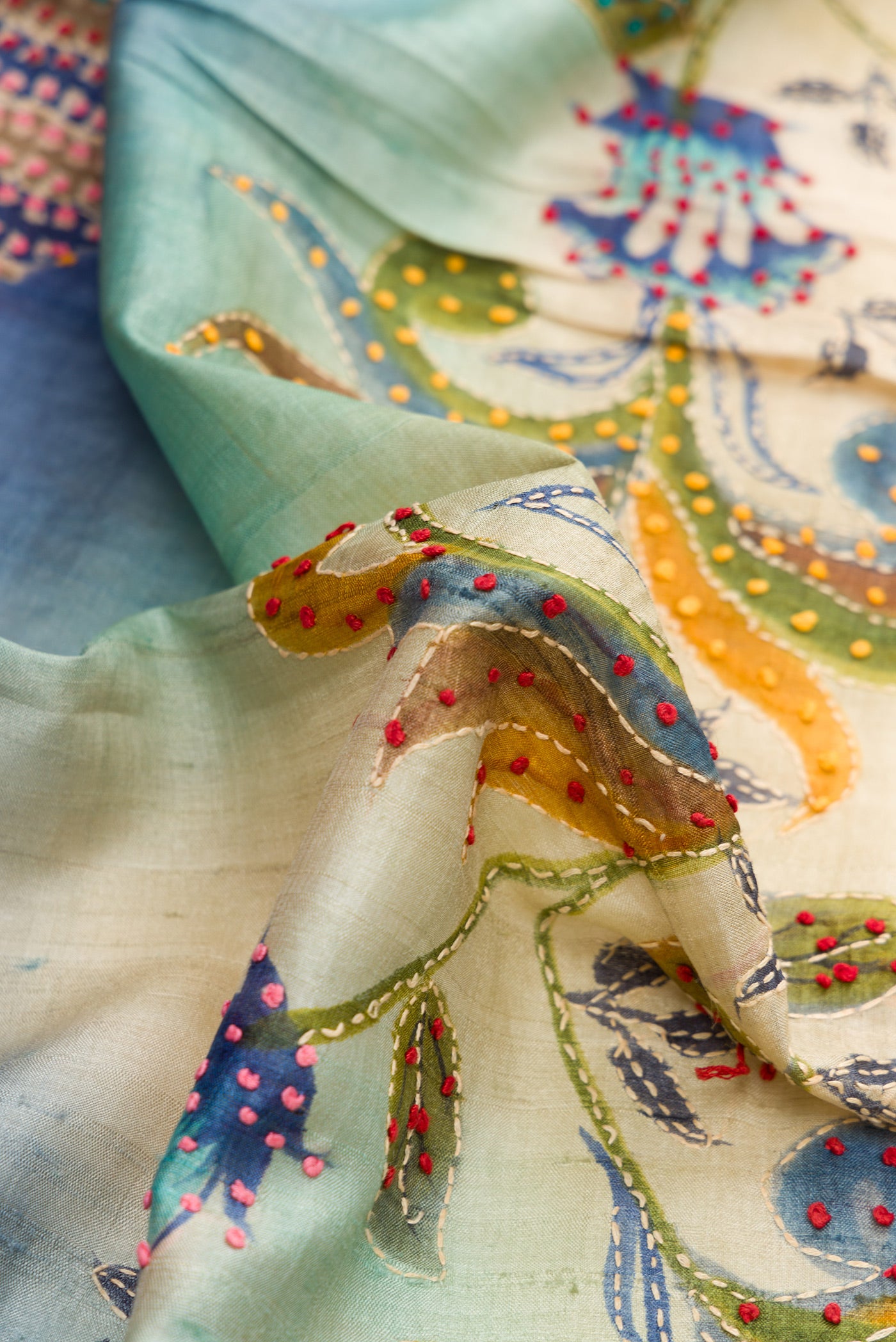 Close up of Blue and Beige Color Tussar Saree with Printed design on the body and Embroidery Border.  displaying folds