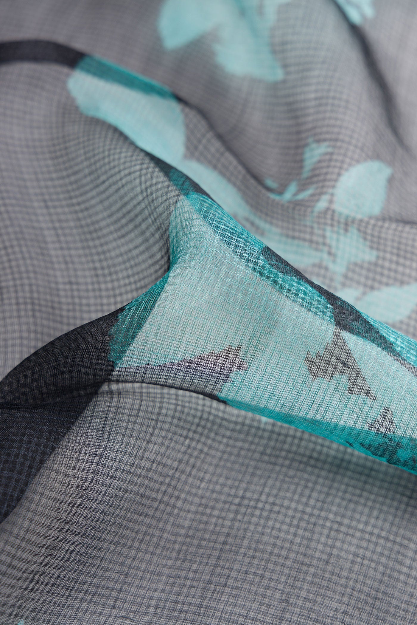 Close up of Black Dual Tone Tussar Silk Saree with Printed design on the body and Zari Border.  displaying folds