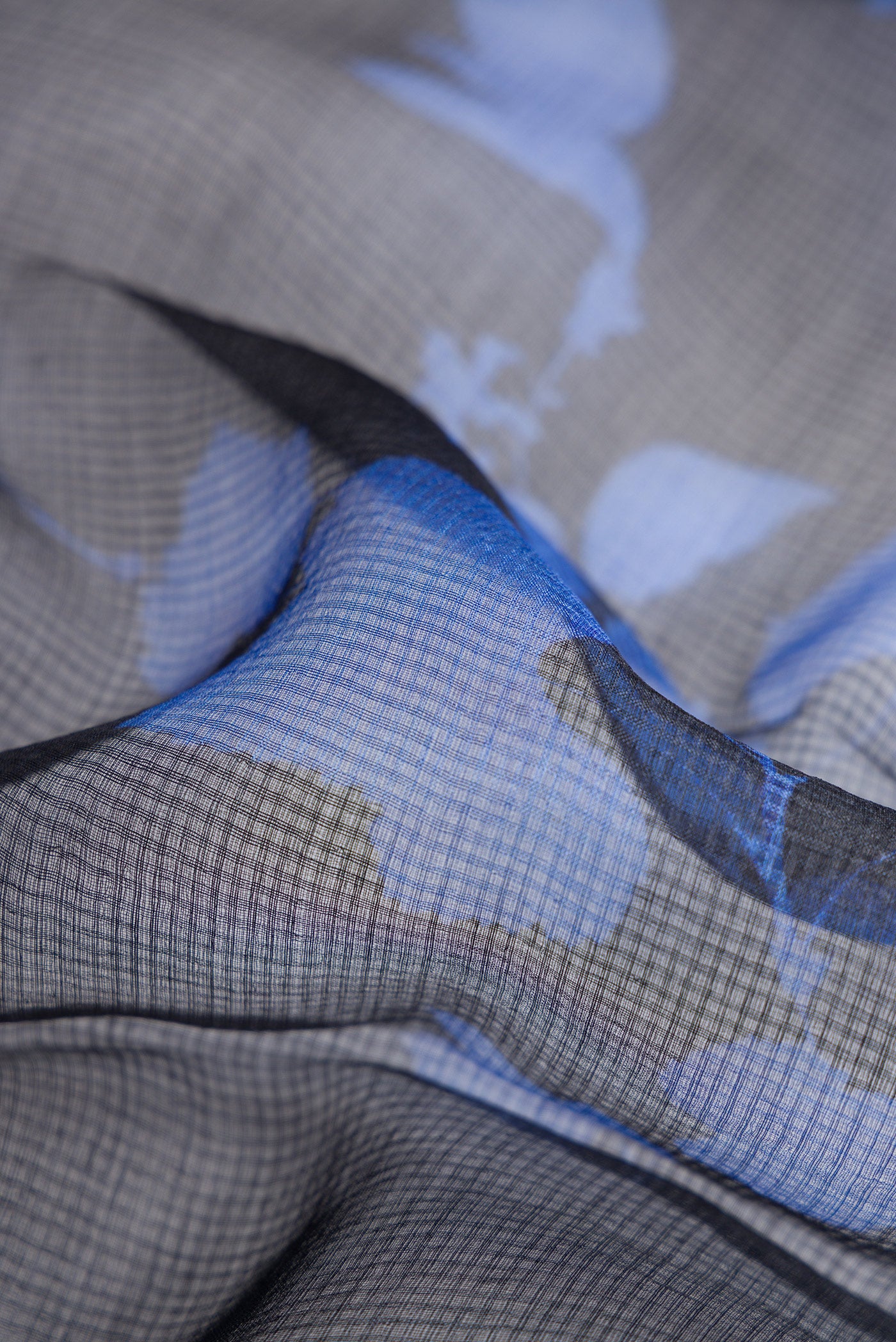 Close up of Black Dual Tone Tussar Silk Saree with Printed design on the body and Zari Border.  displaying folds
