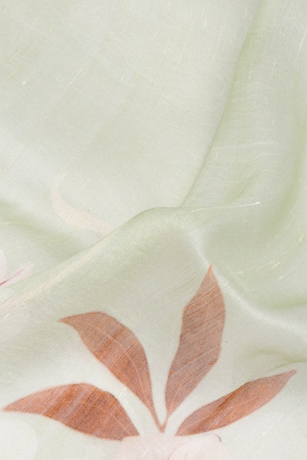 Close up of Pista Green Linen Saree with Printed design on the body and Plain Border.  displaying folds