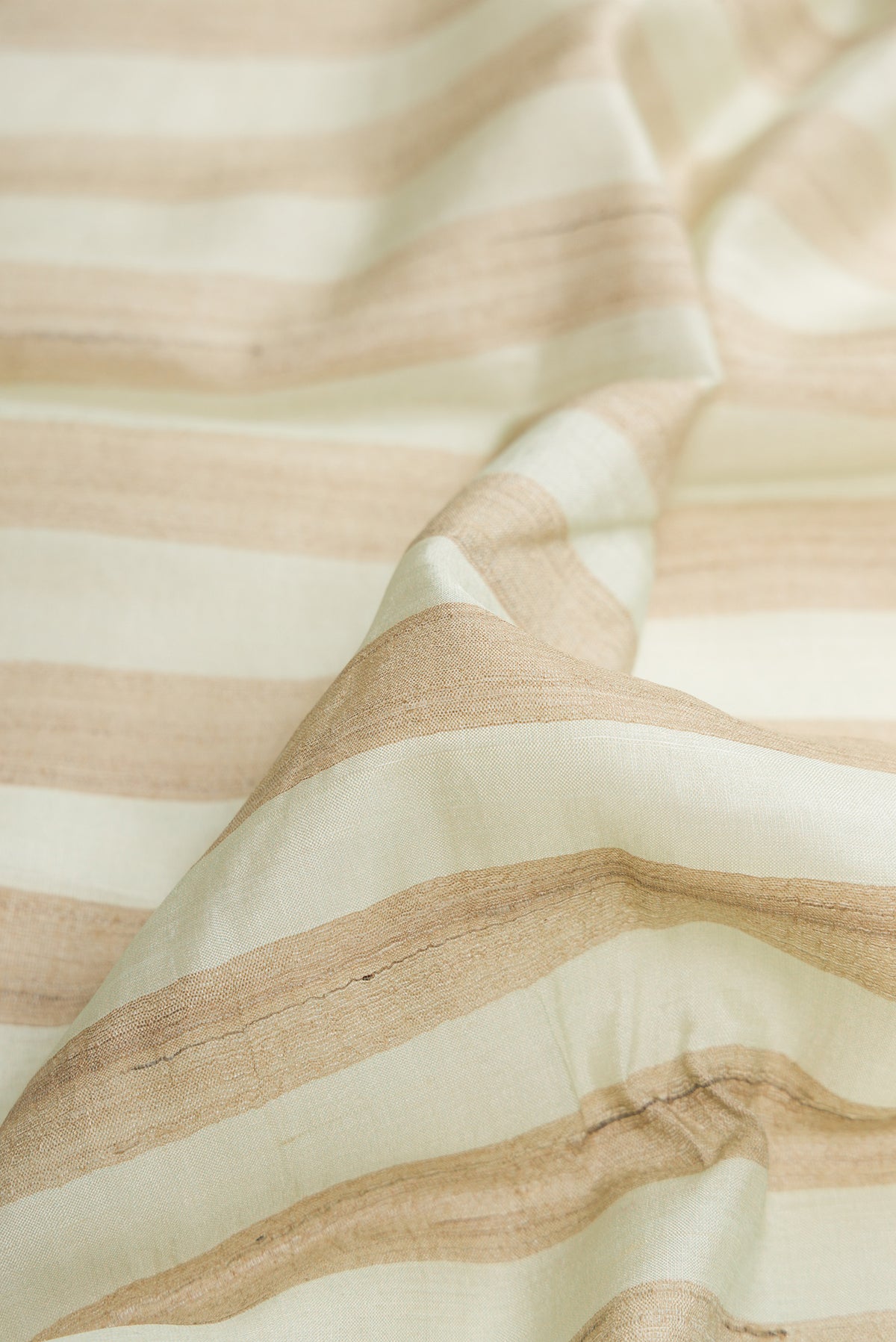 Close up of Pista Green Dual Tone Tussar Silk Saree with Stripes on the body and Fancy Border.  displaying folds