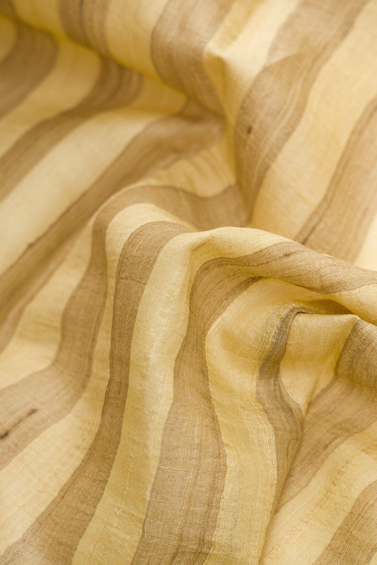 Close up of Yellow Dual Tone Tussar Silk Saree with Printed design on the body and Zari Border.  displaying folds