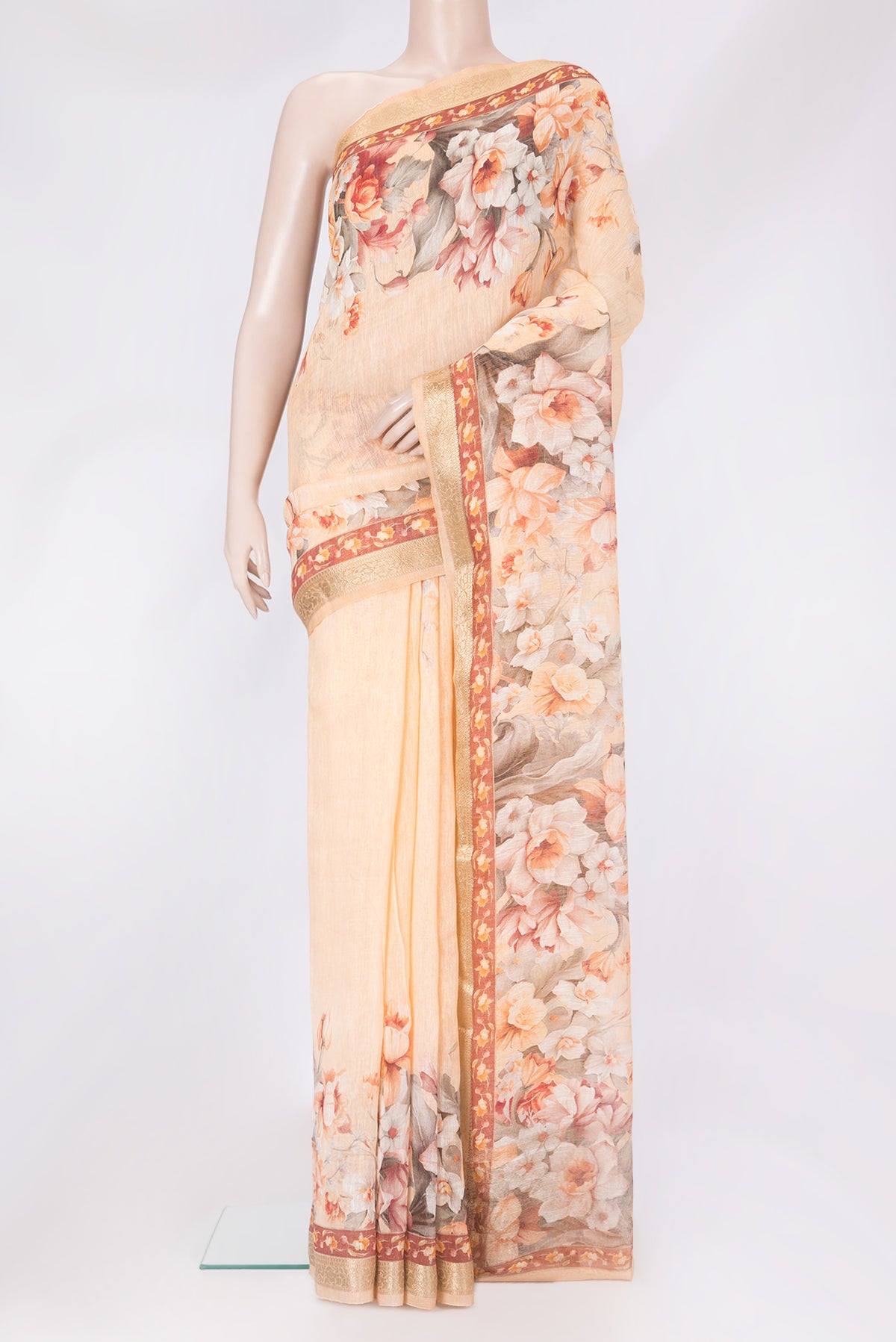 Golden Peach Linen Saree with Floral Print on the body and Zari Border.  displayed on a mannequin
