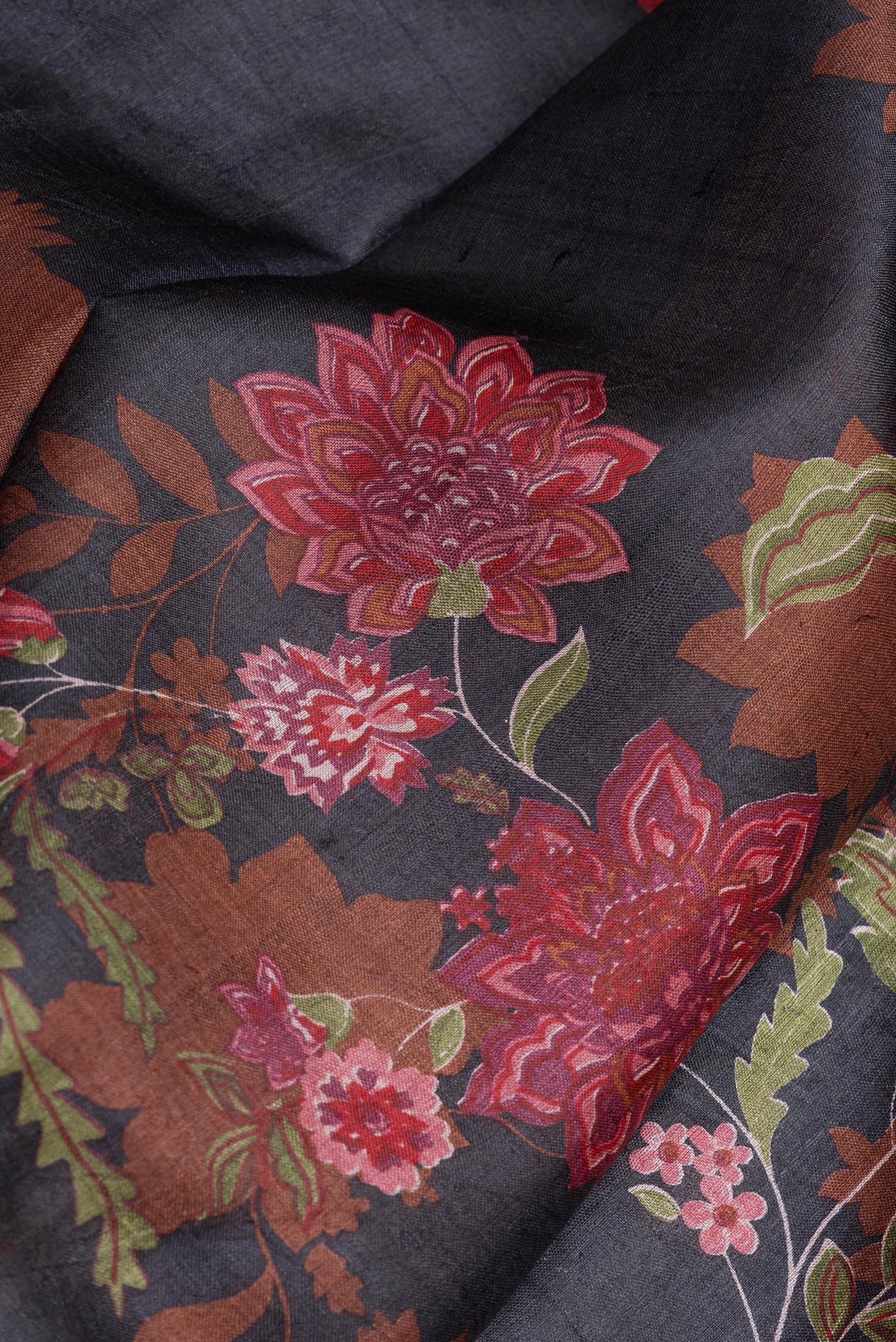 Close up of Black Tussar Silk Saree with Floral Print on the body and Printed Border.  displaying folds