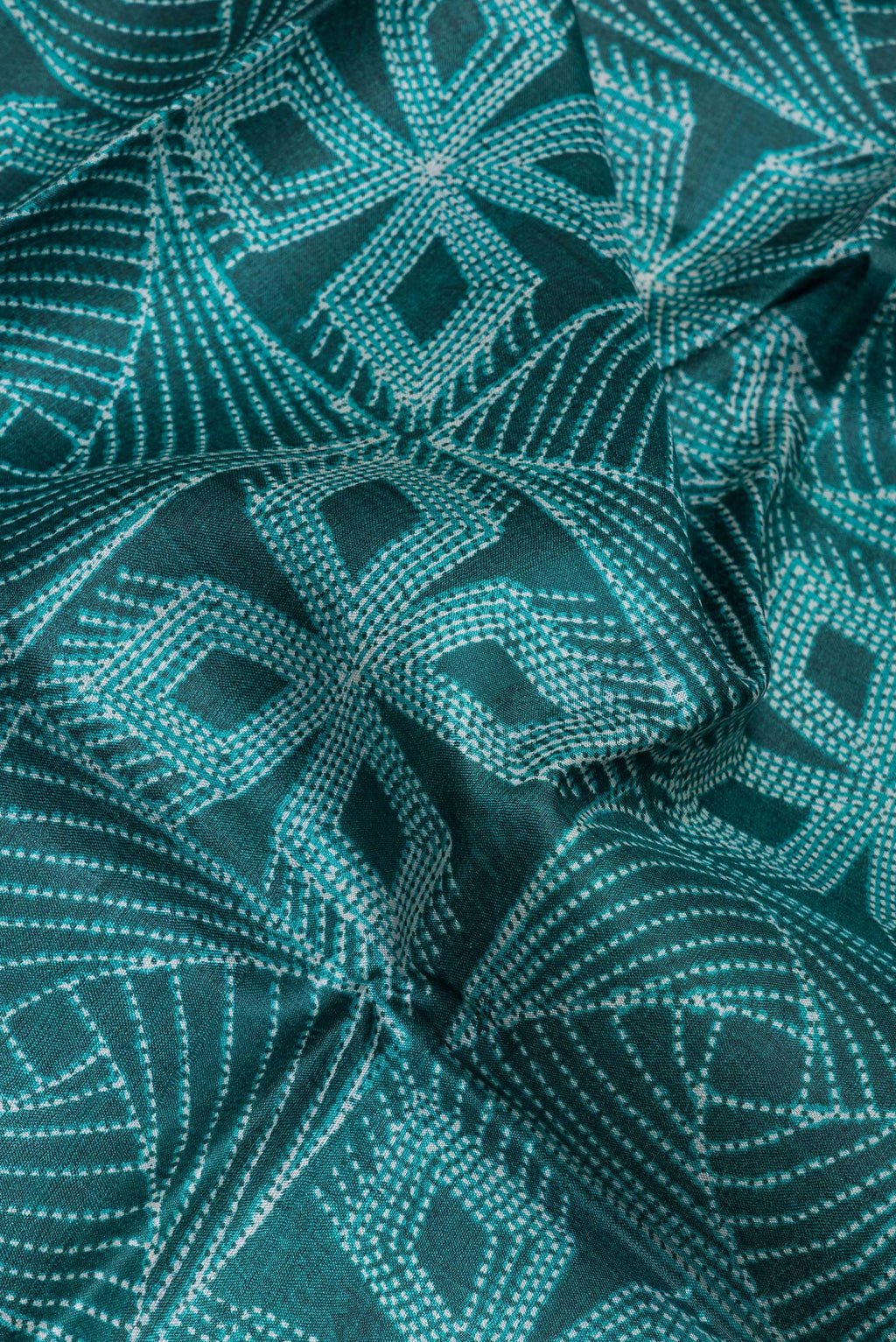 Close up of Bottle Green Tussar Silk Saree with Printed design on the body and Printed Border.  displaying folds